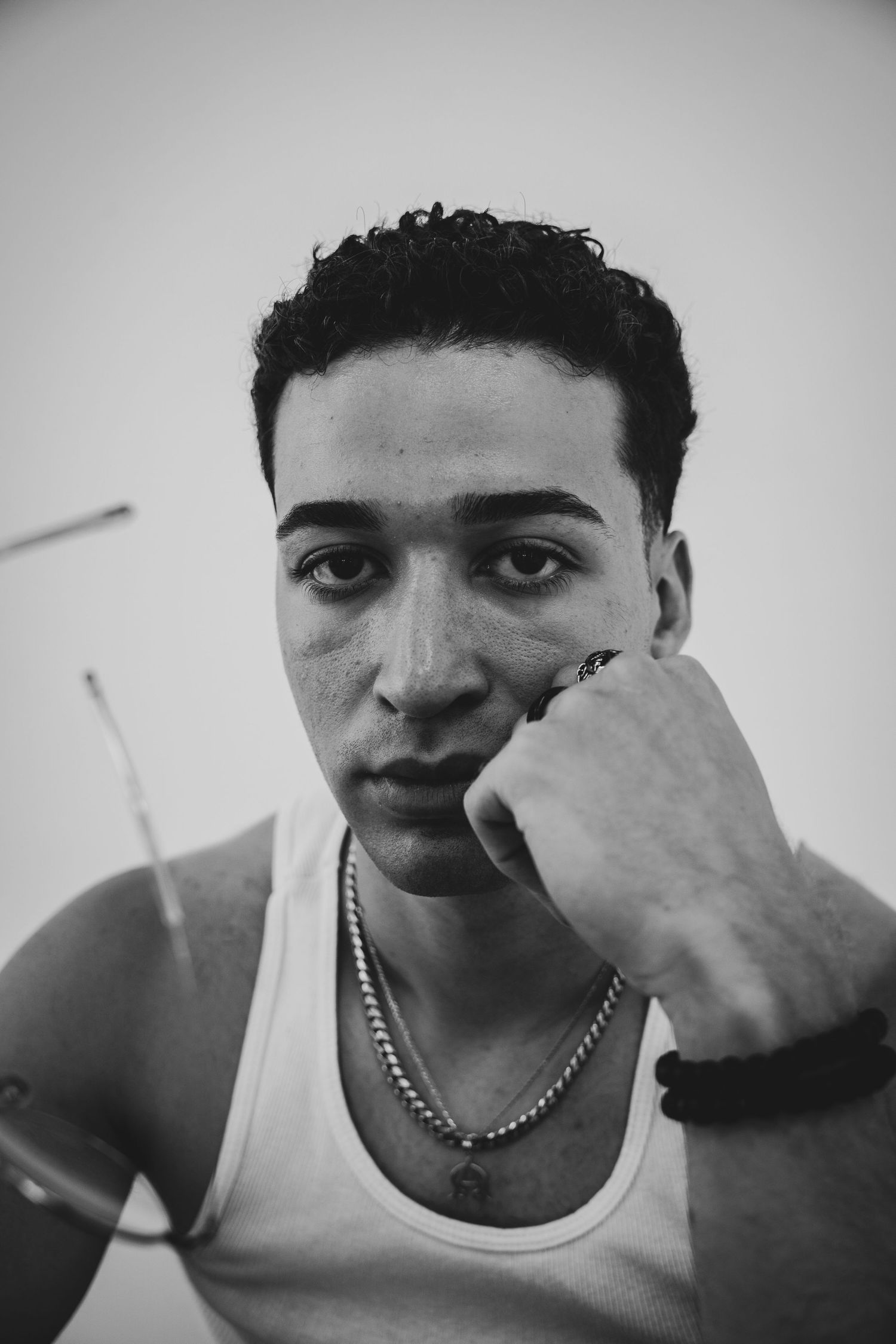 Dramatic monochrome sequence showing different angles of a person wearing a tank top with hand gestures.