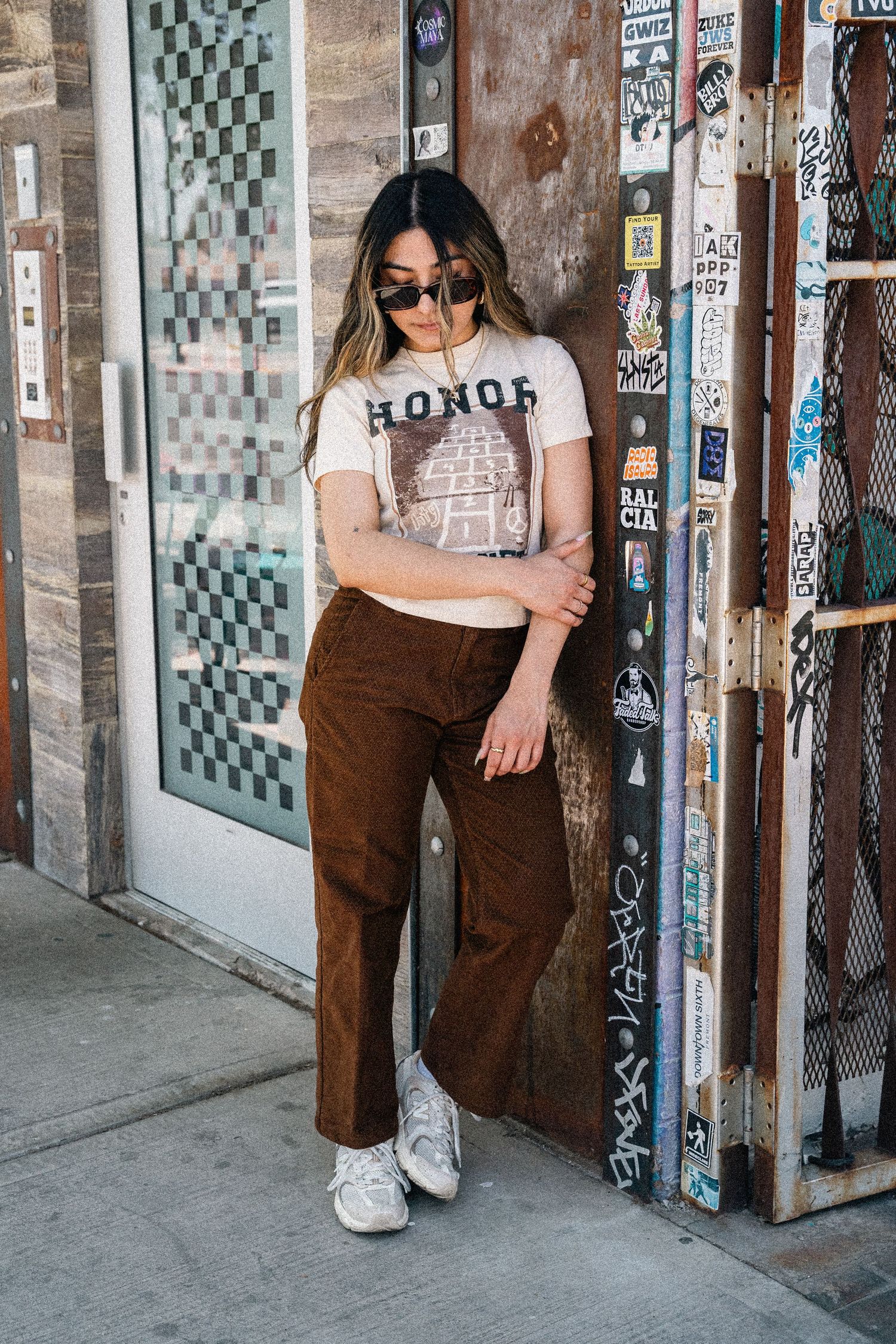 Full length street style photo showing retro outfit with graphic tee and corduroy pants.