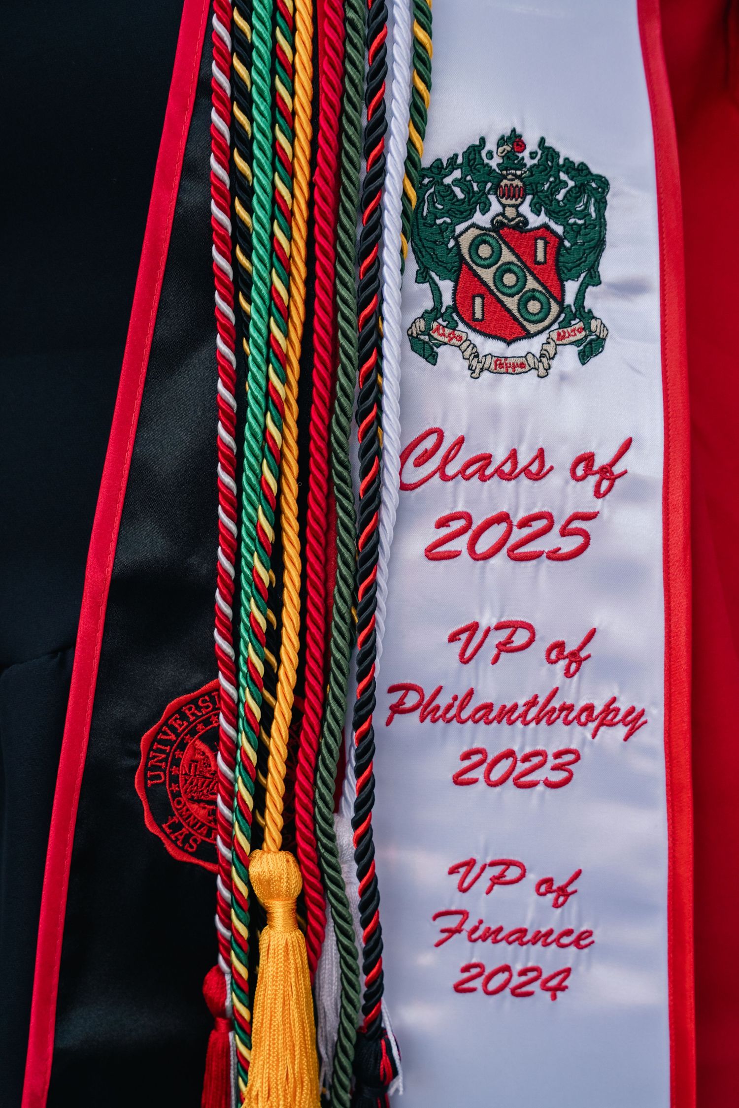 Graduation stole showing Class of 2025 with colorful cords and university emblem.