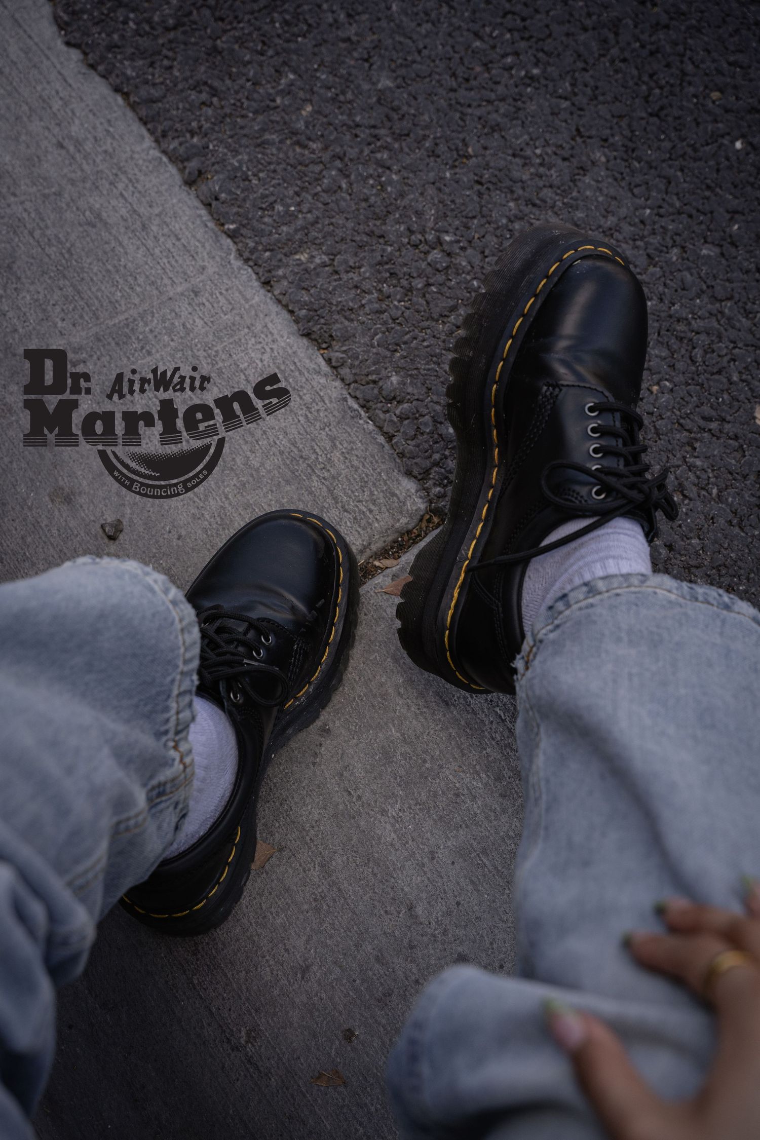 Close-up sequence of black Dr. Martens boots on dark pavement.