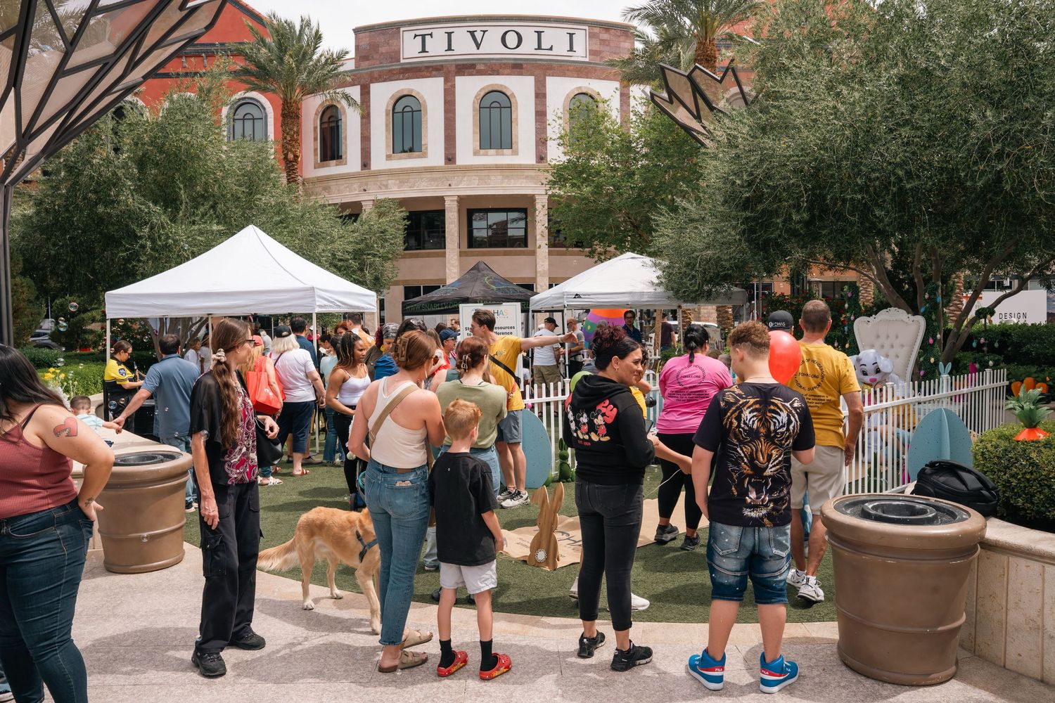 Crowd of people and dogs gathered outside the Rivoli building at a pet-friendly outdoor event.