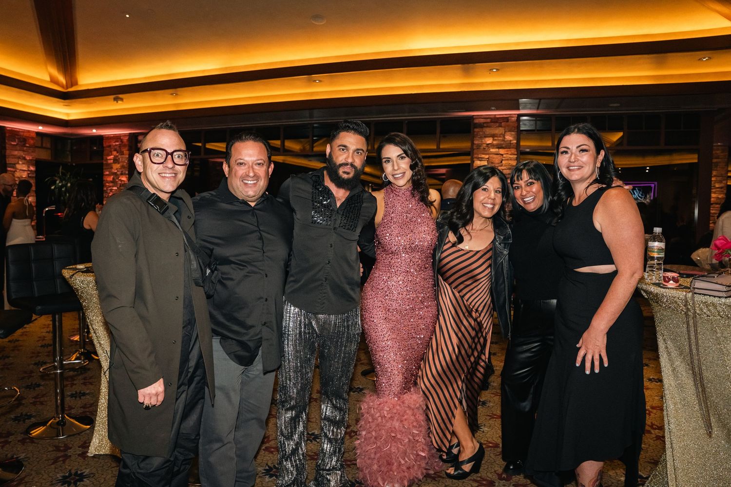 Small group of people in formal attire posing together at an evening event.