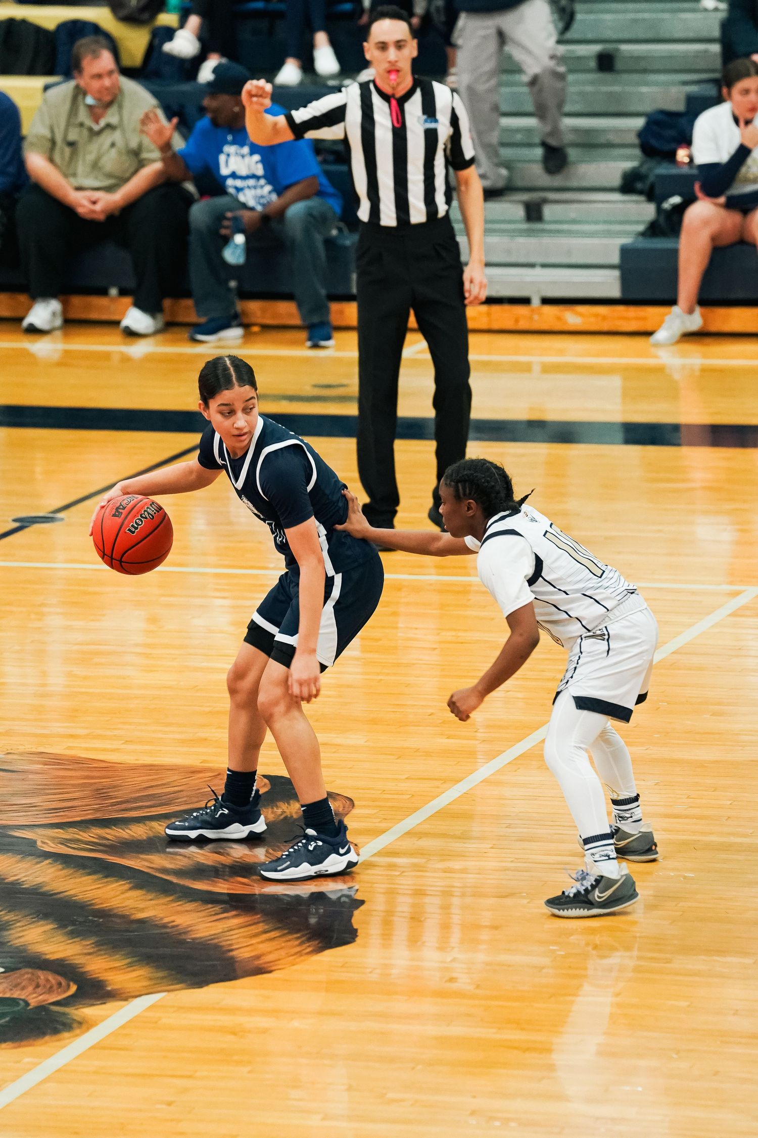 Close-up action shot of basketball players' feet during a game on wooden court.