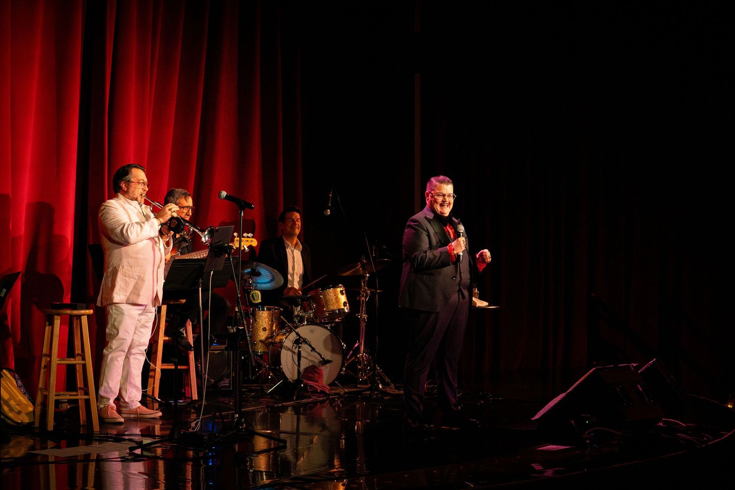Two performers share the stage with a live band during an evening show.