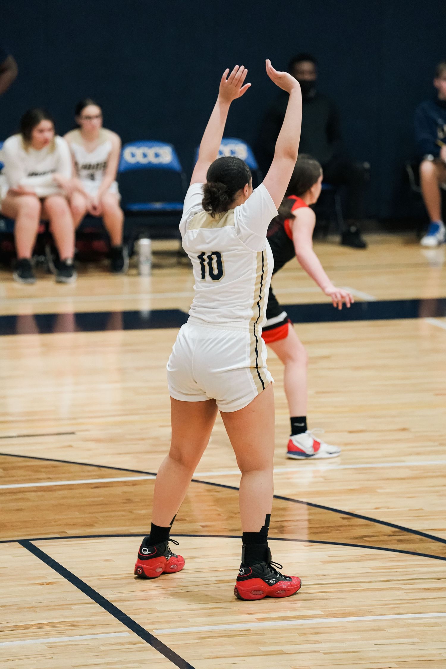 Basketball player signals for the ball while positioned near the baseline.