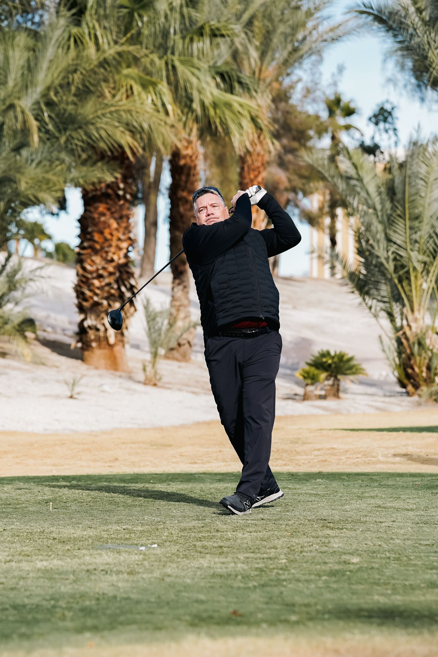 Golfer demonstrating swing technique on a lush green golf course.