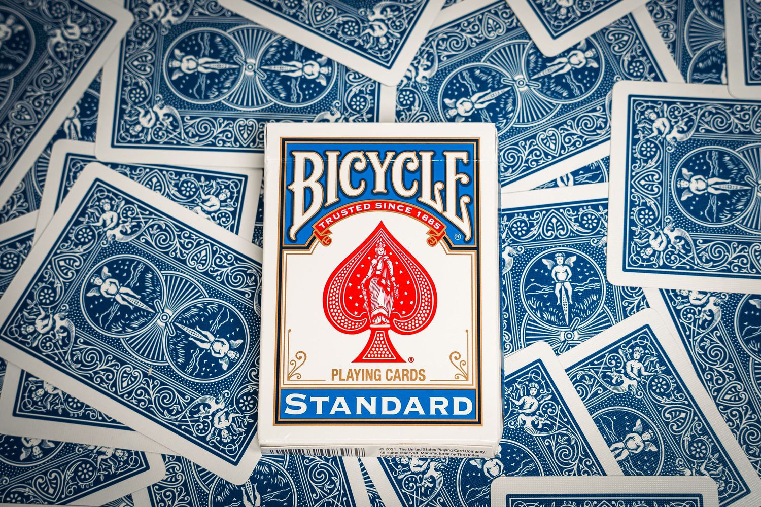 Bicycle playing cards arranged in a fan pattern with the classic red and blue standard deck box.