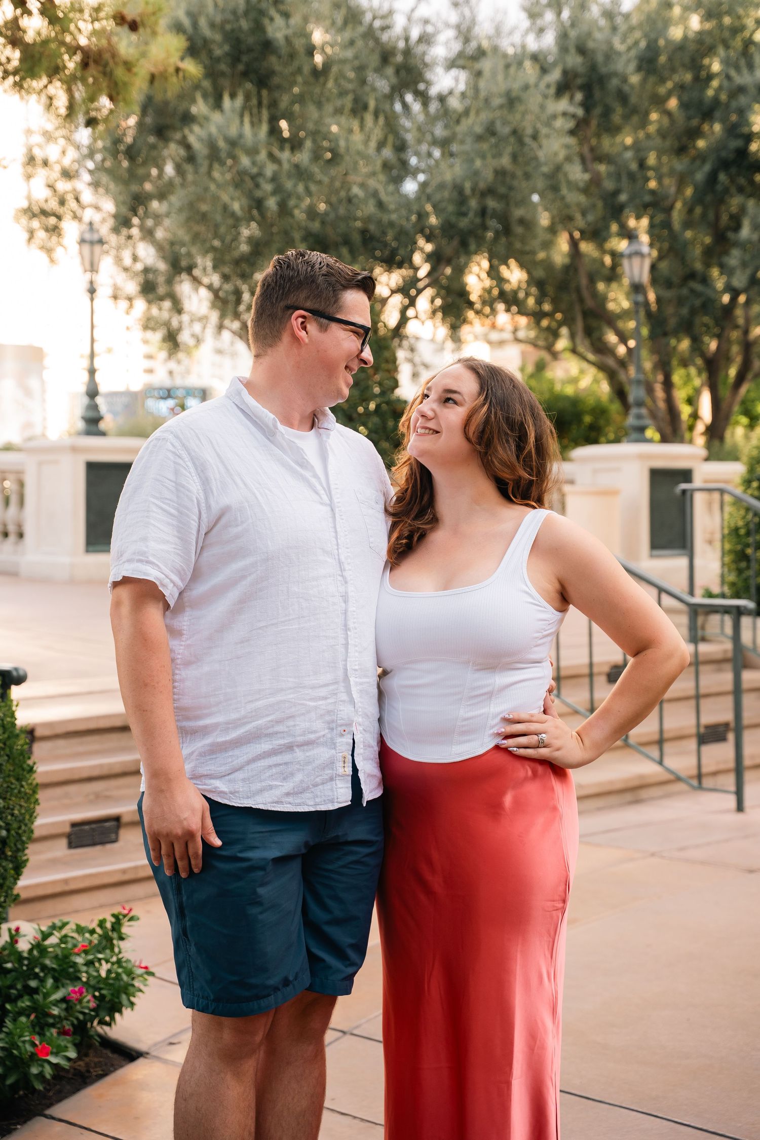 Couple sharing a candid moment while posing for photos on an outdoor terrace.