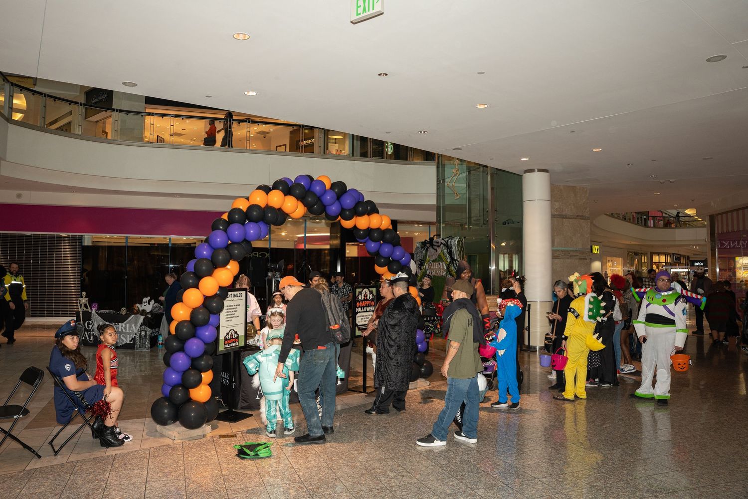 Wide view of convention hall decorated with colorful balloons and displays.