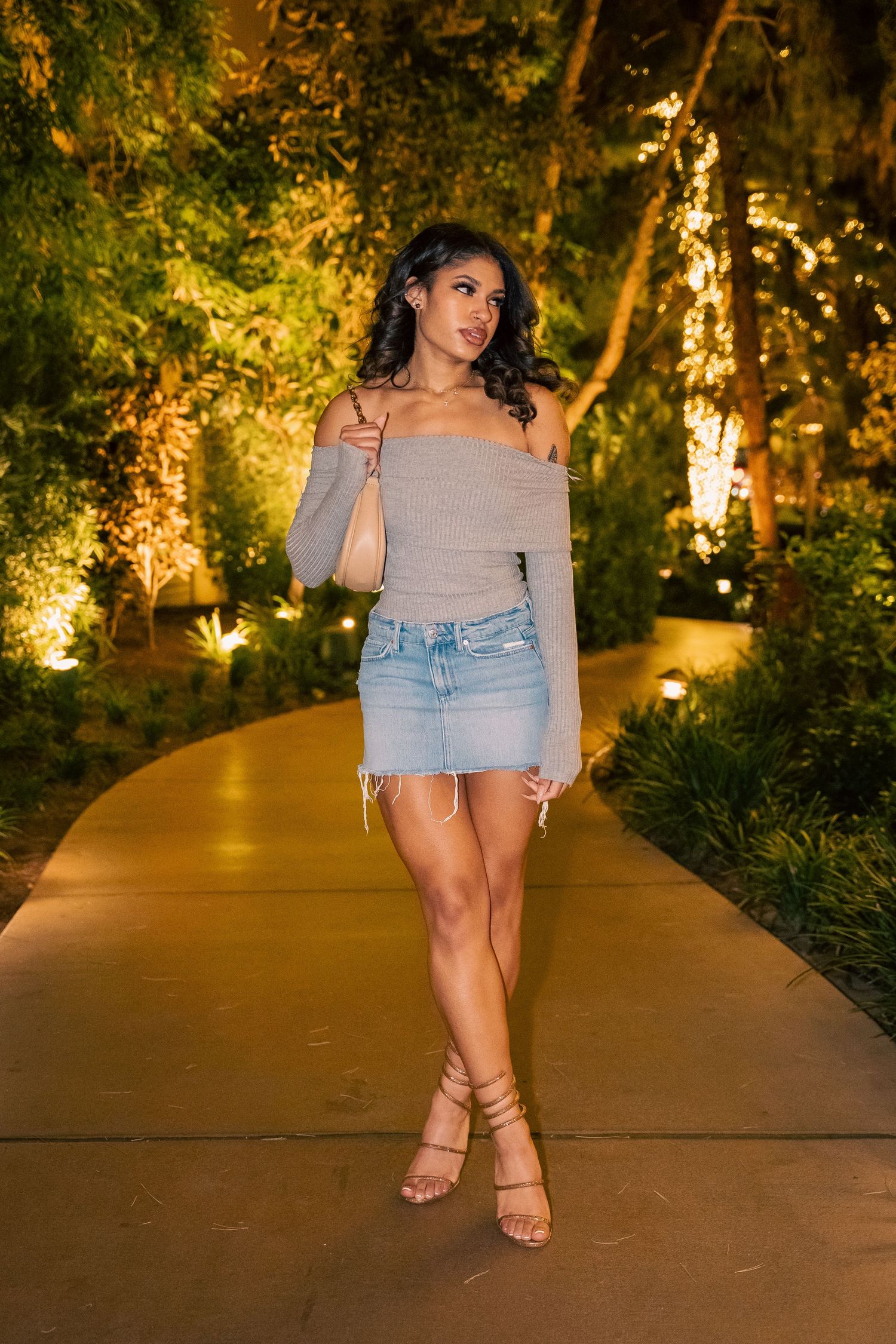 Evening fashion photo on garden path with grey top and denim mini skirt.