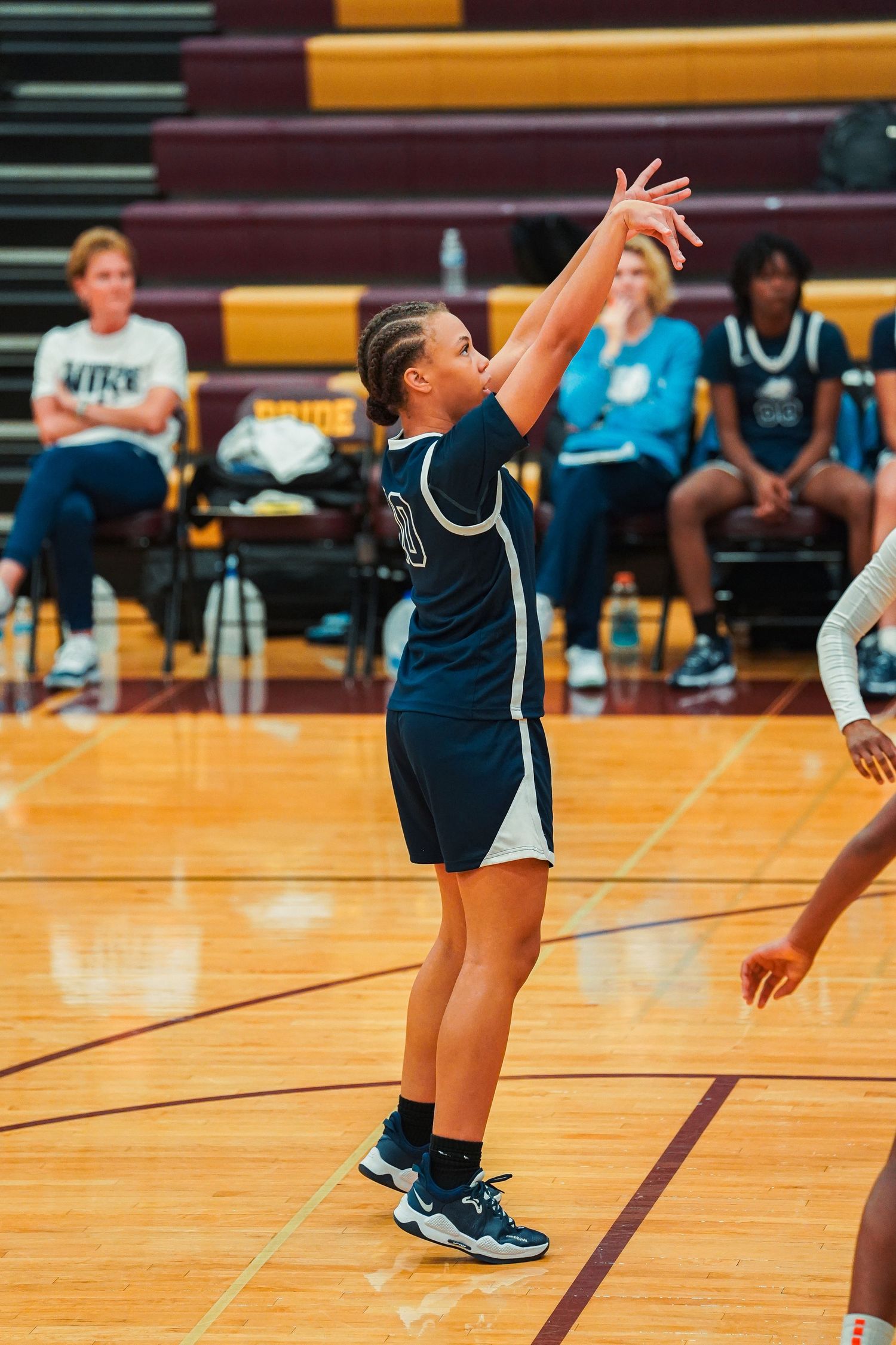 Basketball players practice offensive moves and footwork on the gymnasium court.