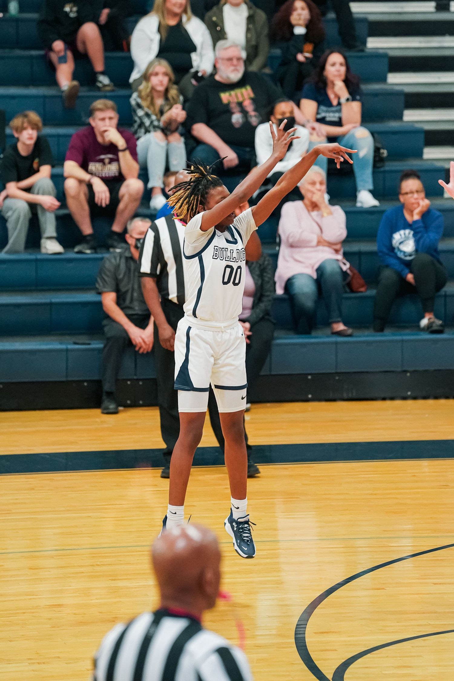 Basketball player prepares to take a shot during a game on a wooden court.