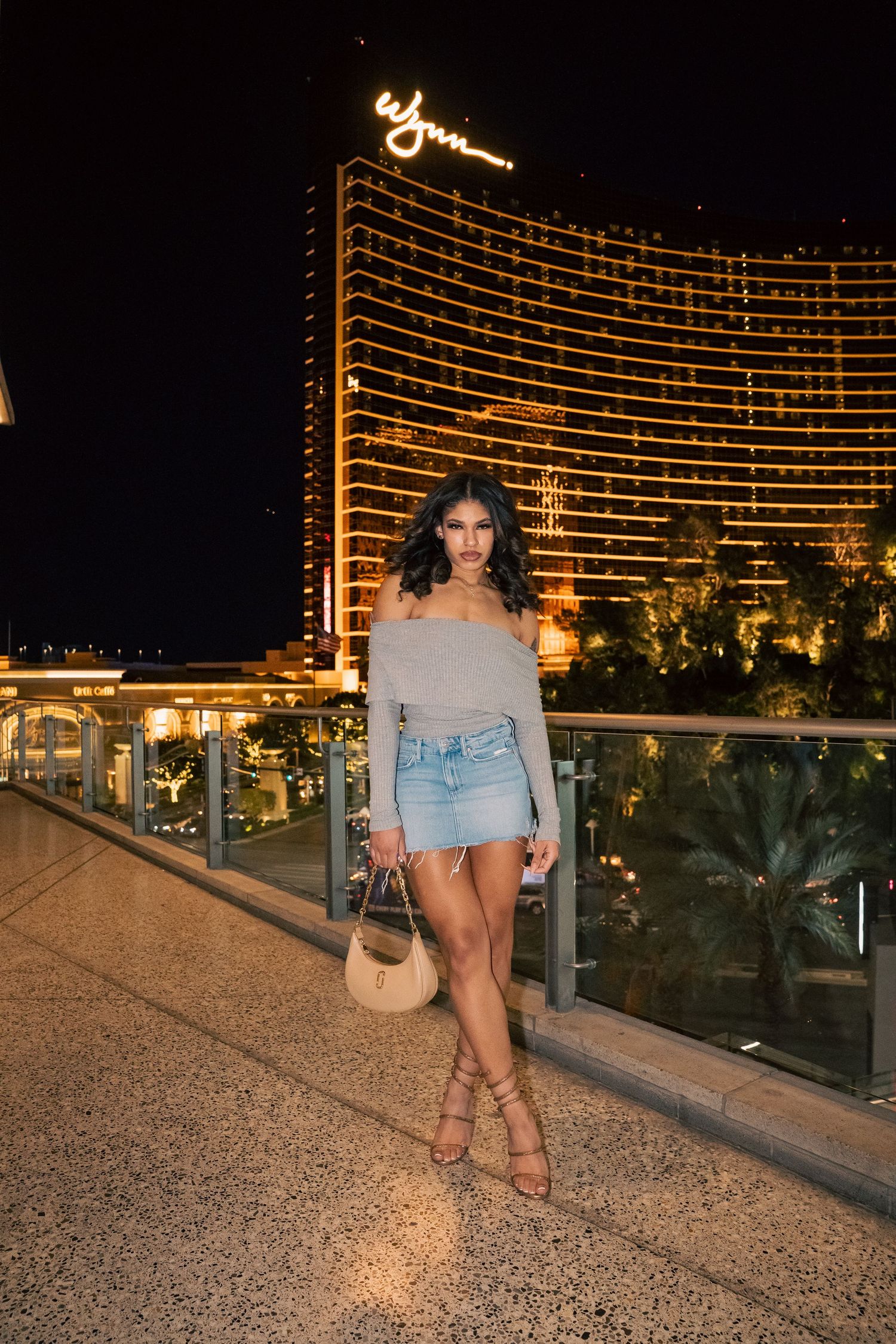 Fashion portrait on hotel balcony with illuminated Wynn Las Vegas in background.