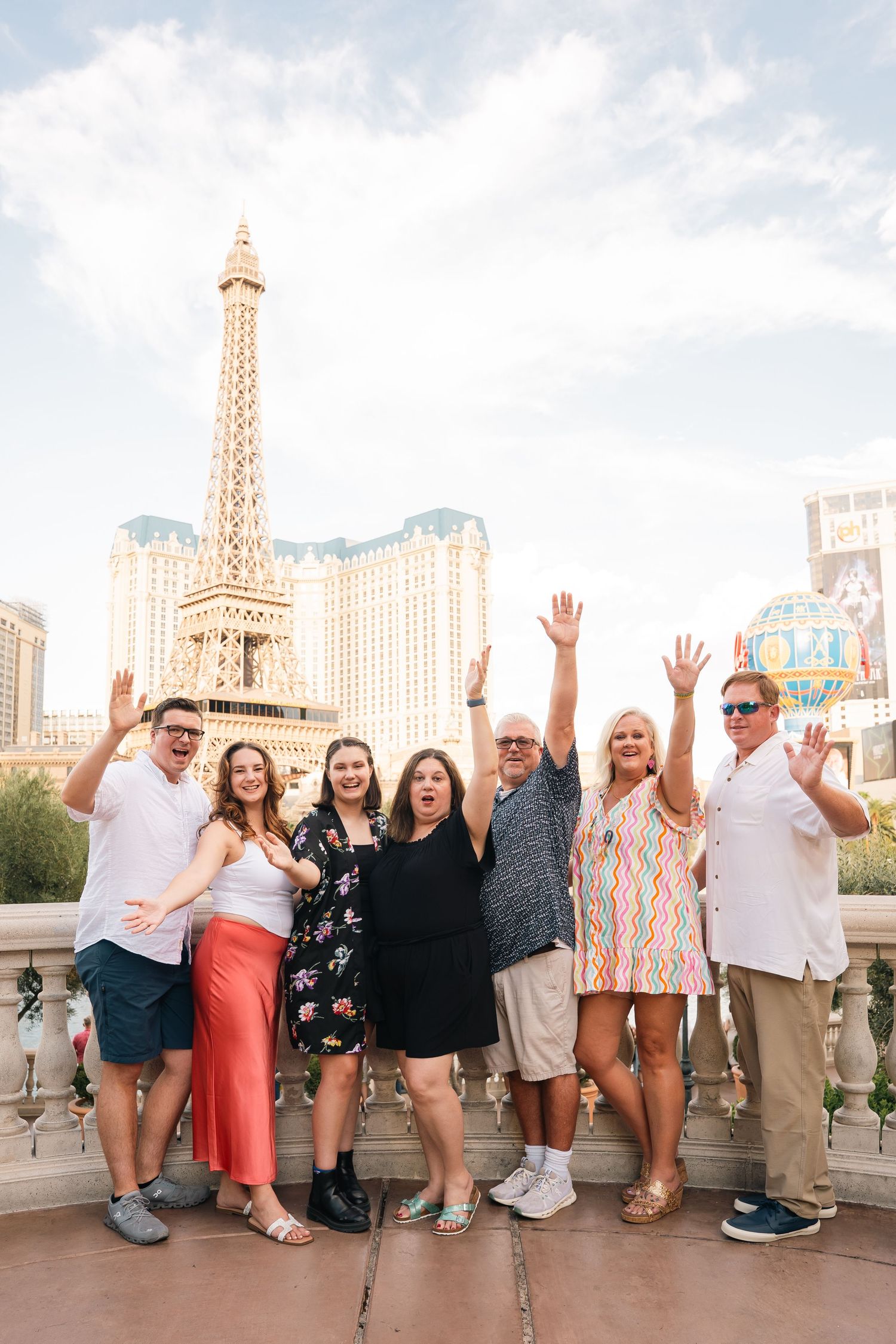 Group photo with raised hands in front of Paris Las Vegas Hotel Eiffel Tower replica.
