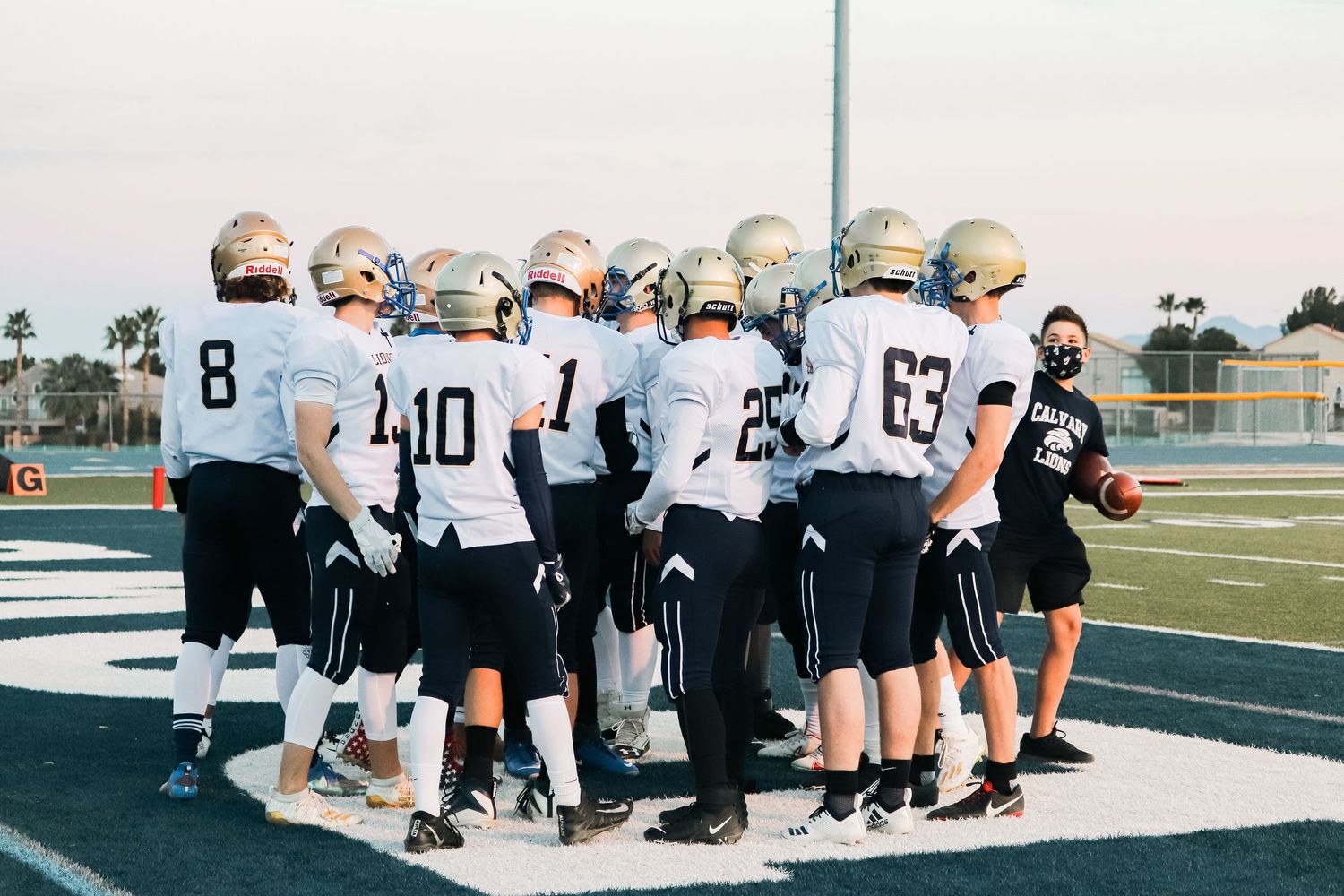 Football players stretching together on the field during practice.