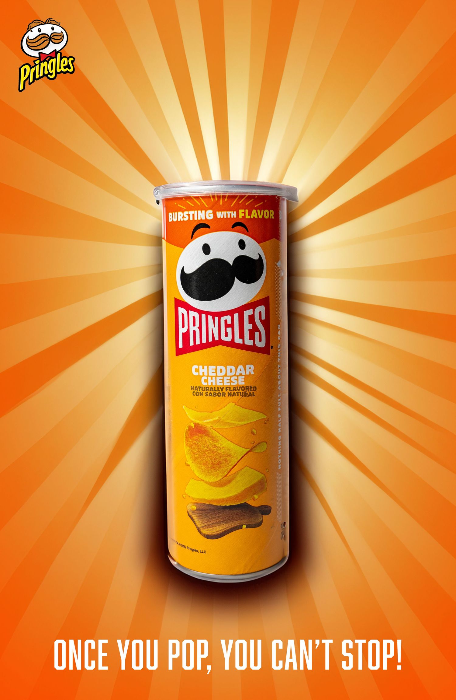 Pringles cheddar can with sunburst background and brand slogan.