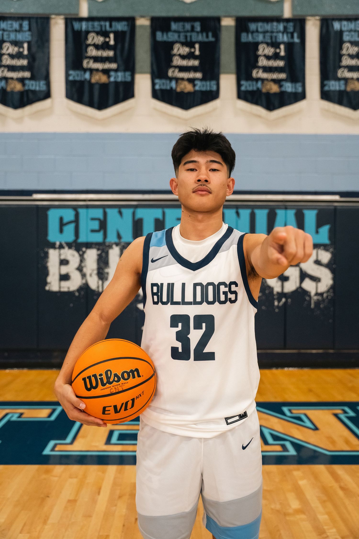 Basketball player in Bulldogs jersey number 32 poses with ball on court.