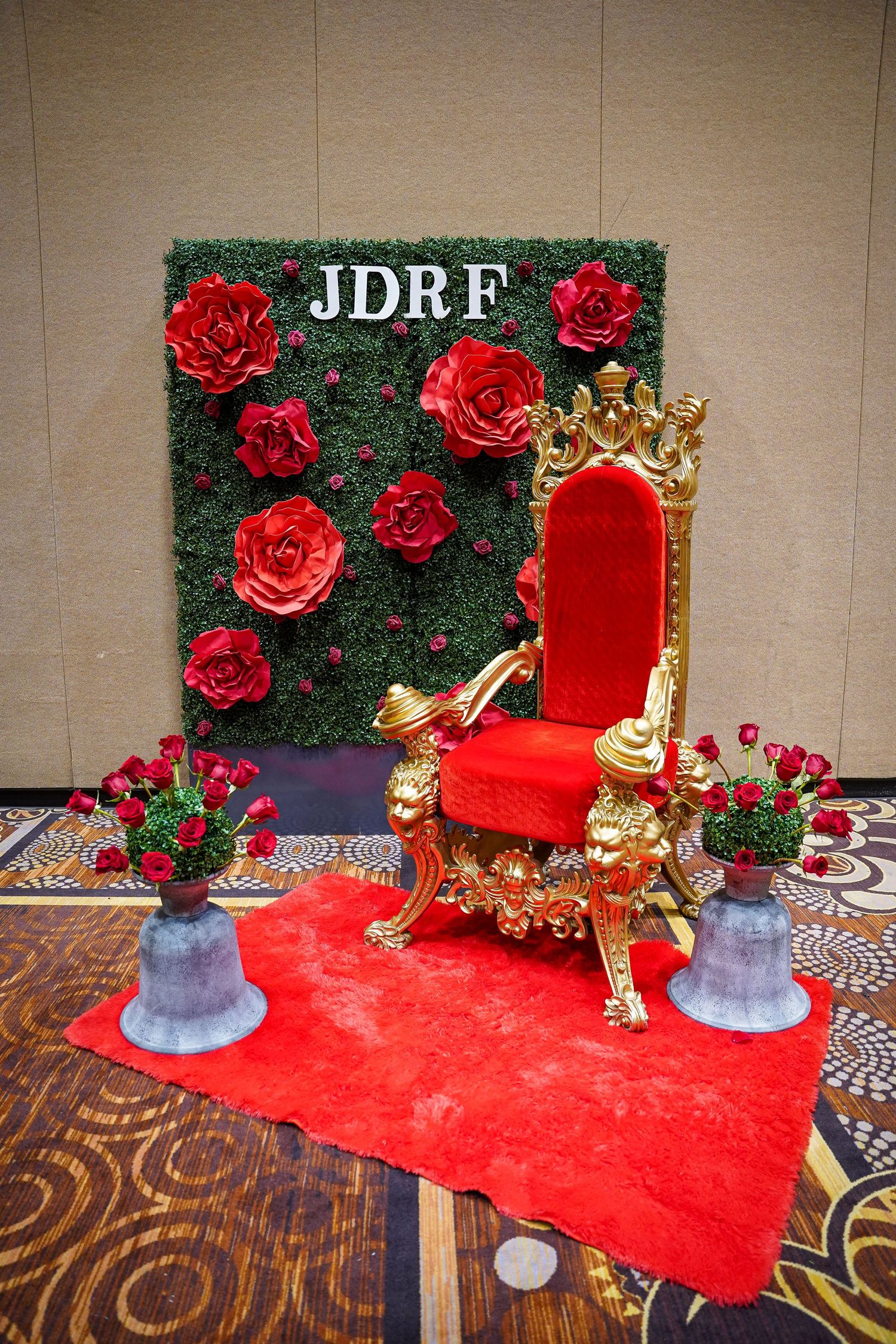 Empty JDRF photo area showing red carpet, floral wall, and golden throne setup.