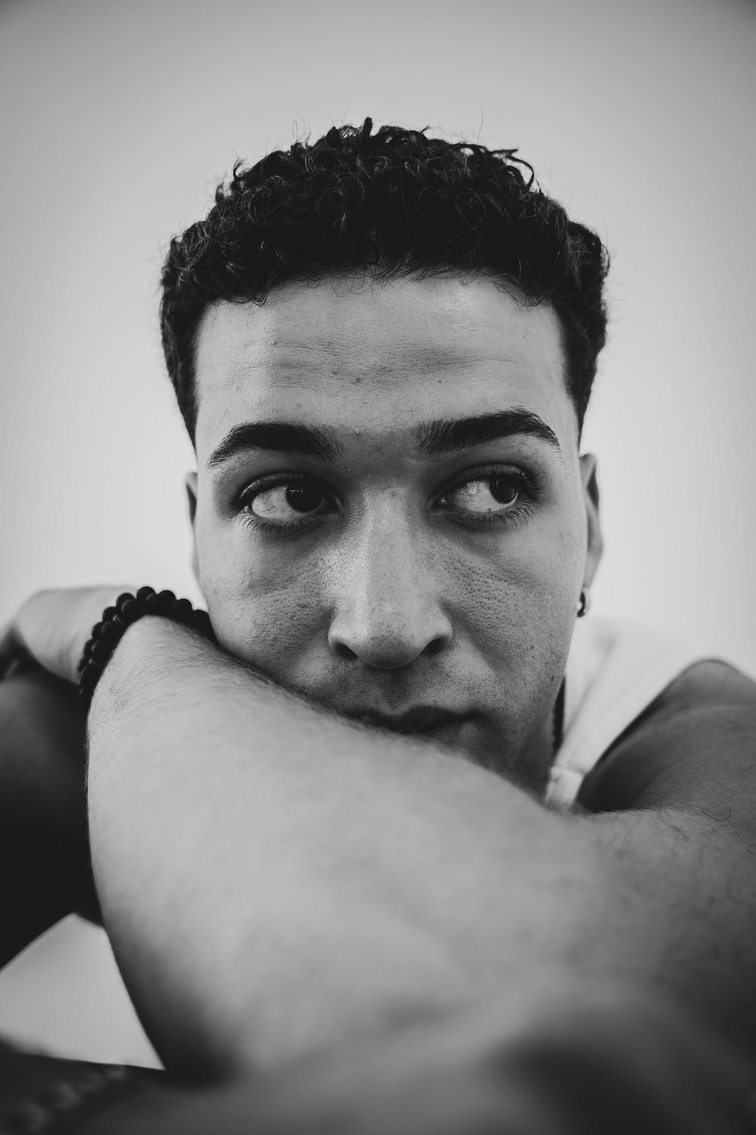 Intimate black and white portrait capturing a thoughtful sideways glance.