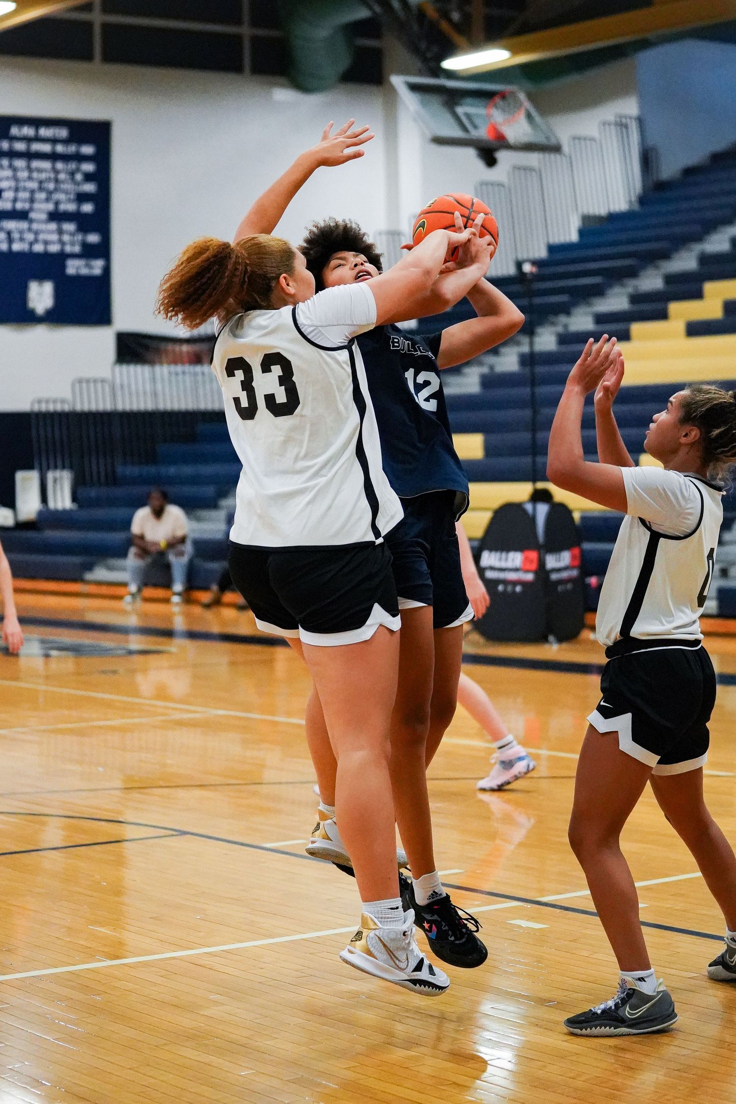 Players practice defensive moves and positioning during a basketball training session.