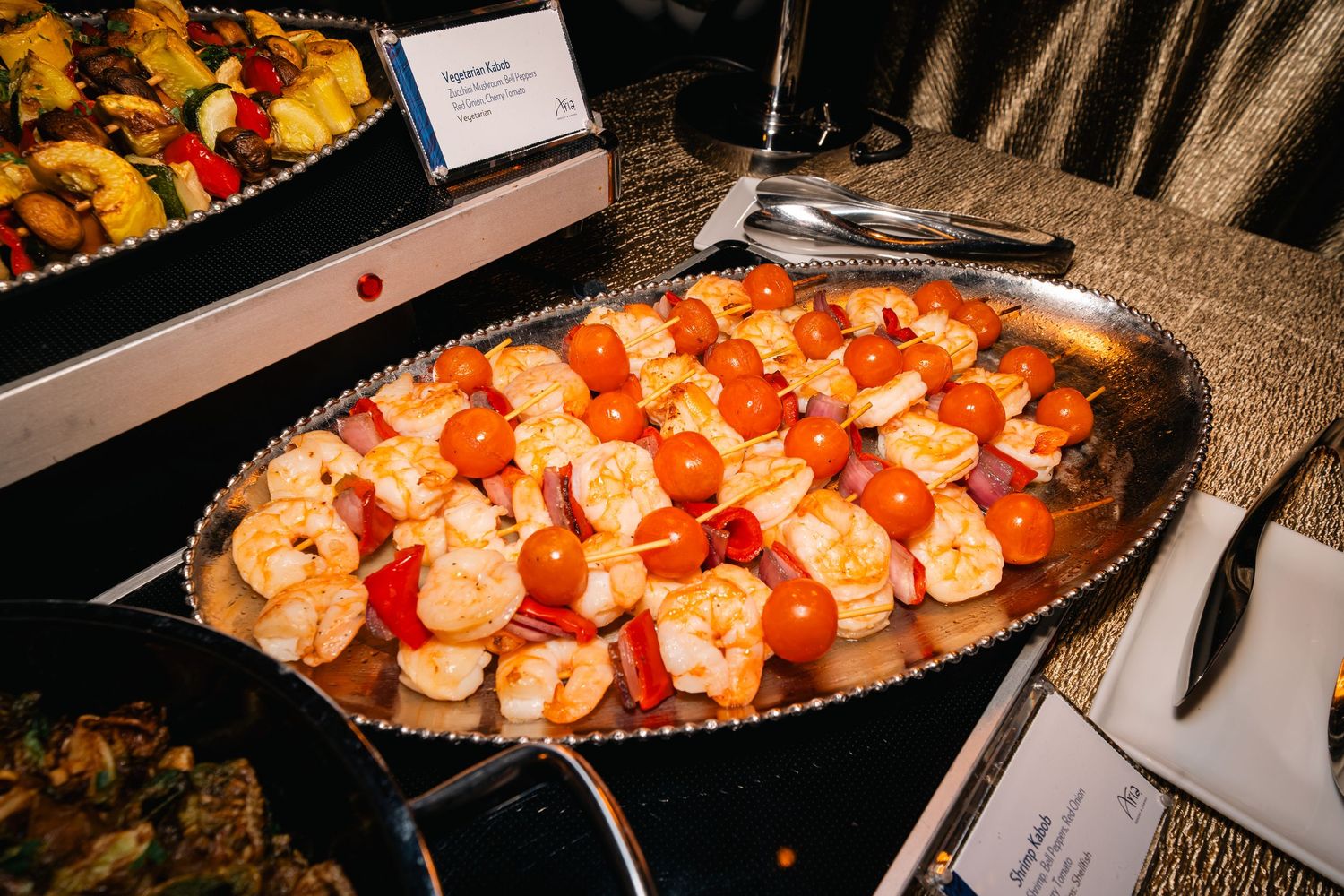 Silver platter of beautifully arranged shrimp cocktail appetizers on display at catered event.