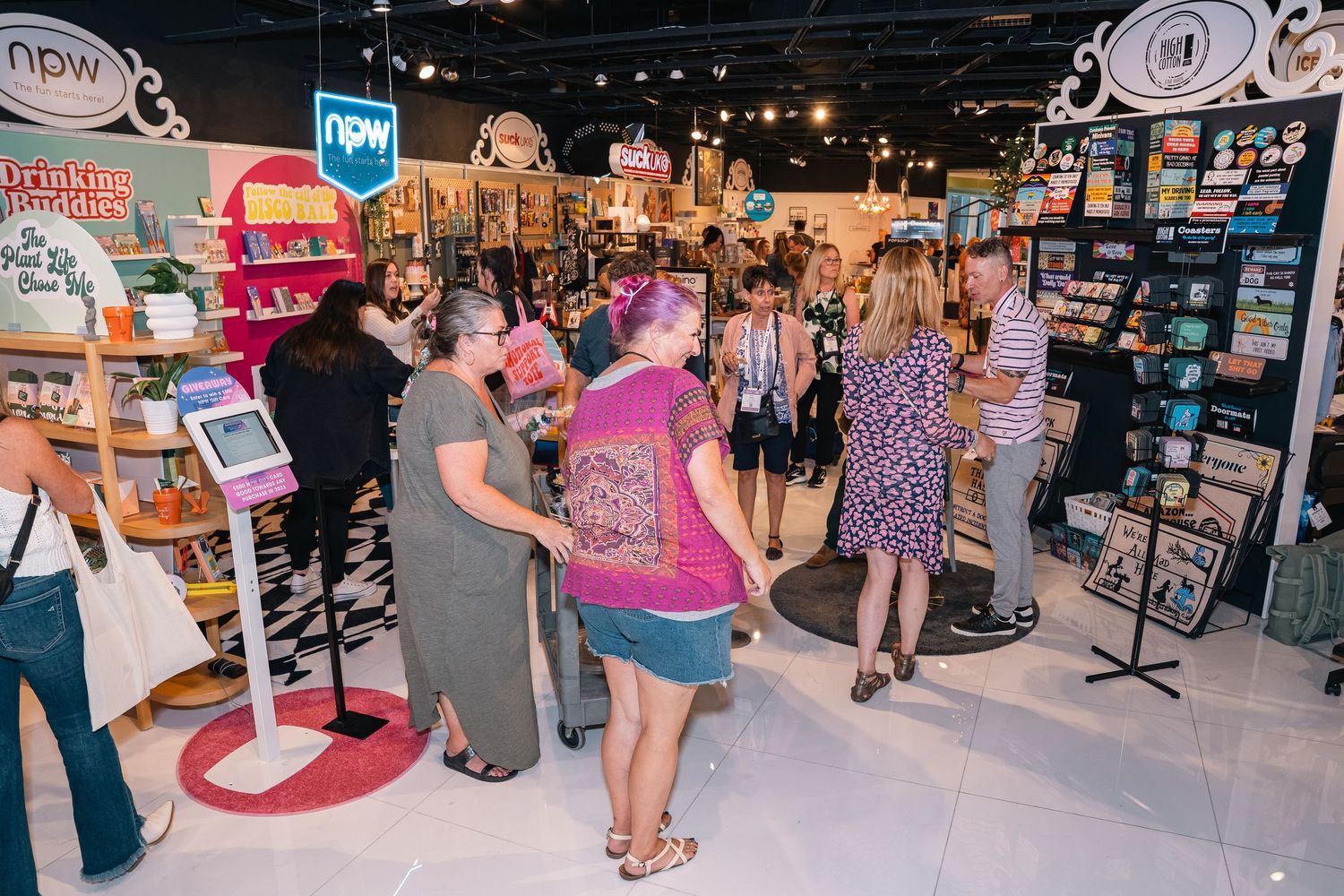 Busy retail store interior with customers browsing merchandise displays and signage.