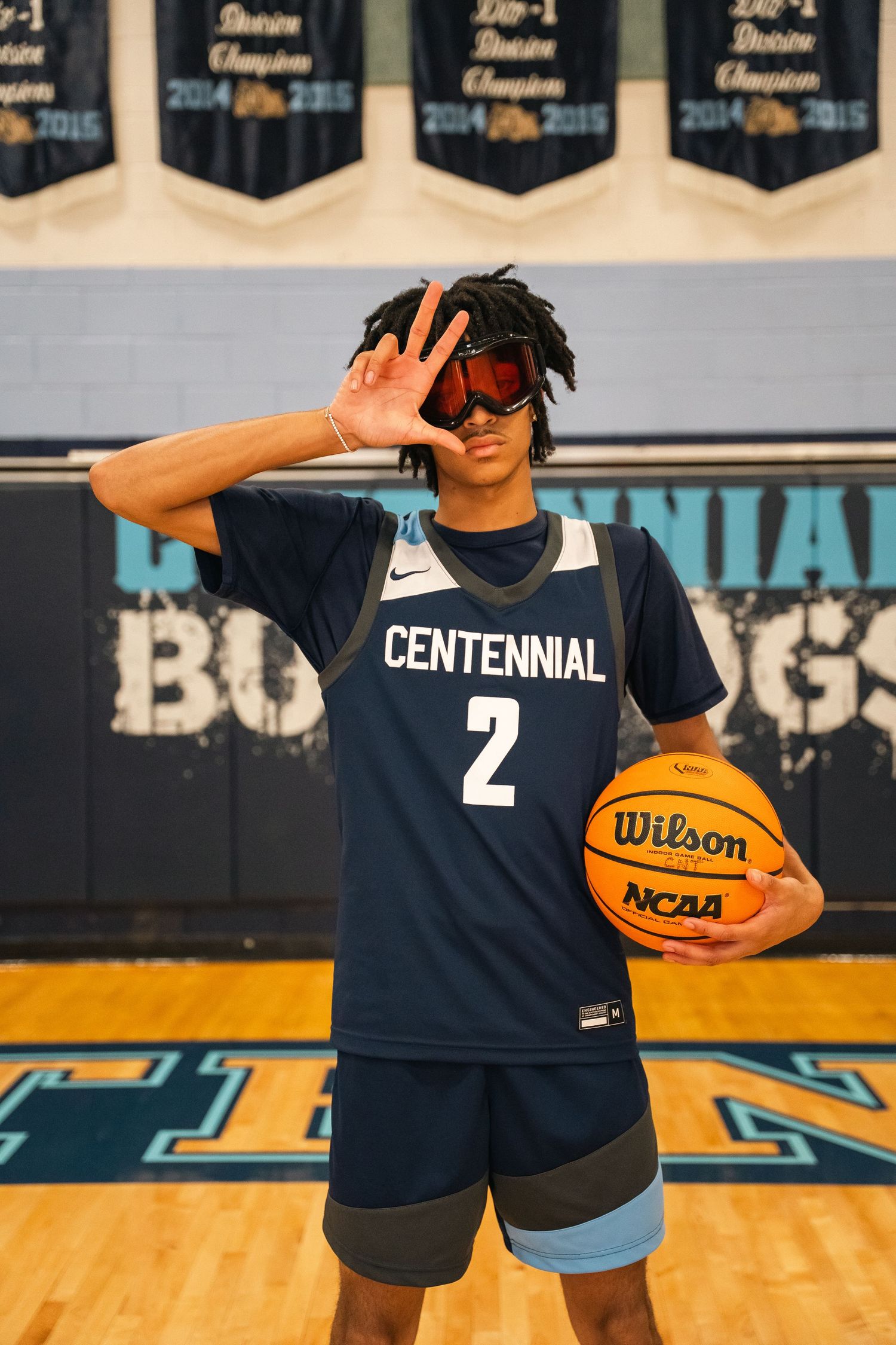 Basketball player in Centennial jersey number 2 poses with ball and sunglasses.
