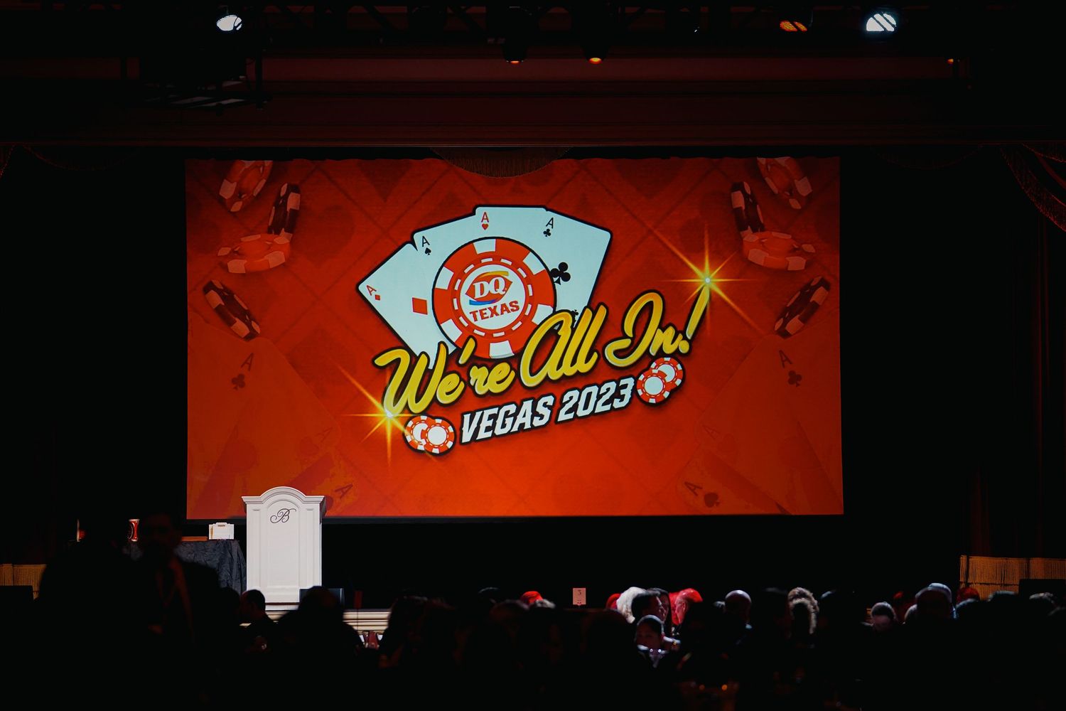 Red illuminated stage backdrop with Vegas themed signage and casino imagery.