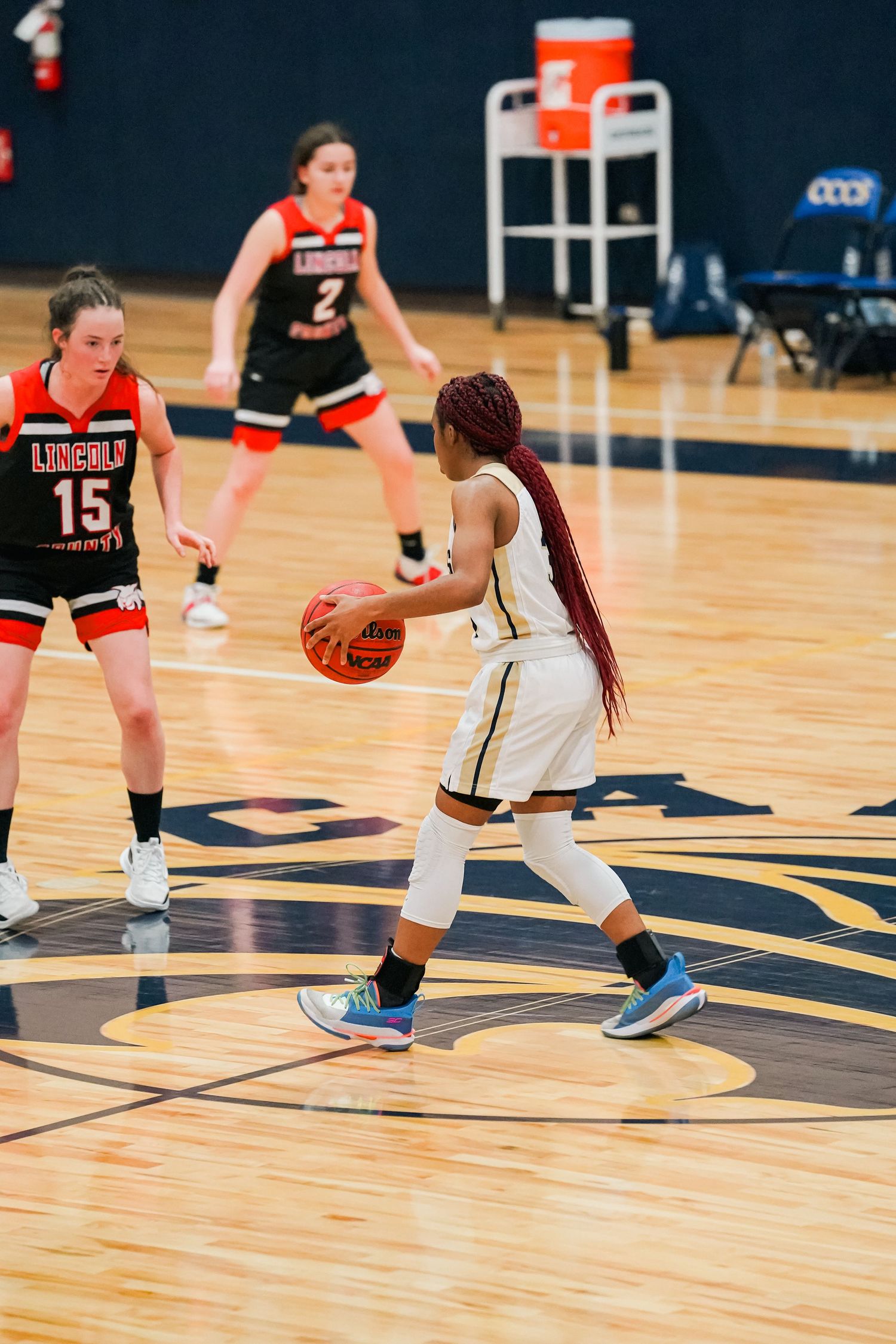 Basketball player controls the ball while being defended during competitive game.