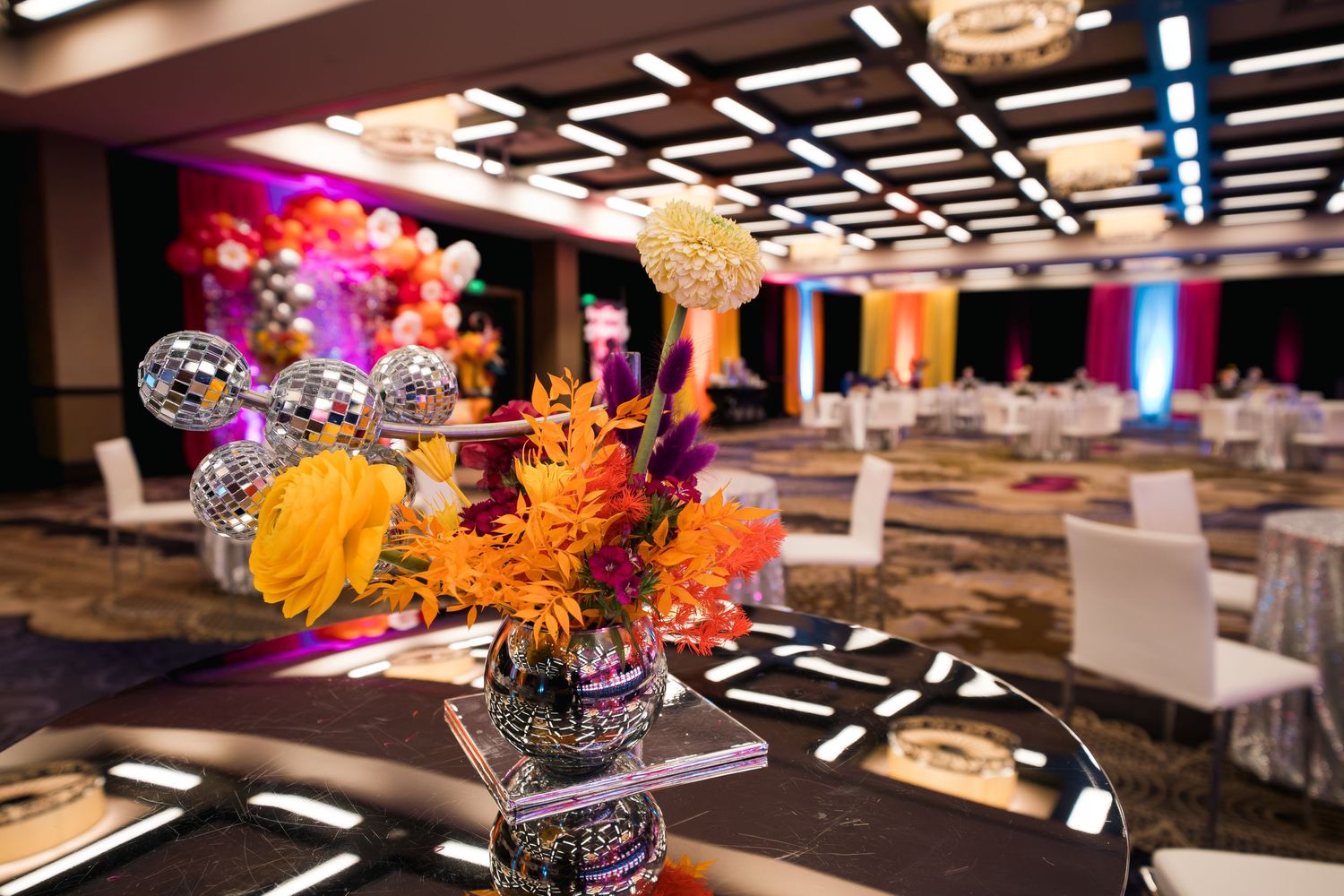 Elegant table setting with dramatic floral centerpiece and geometric ceiling details.