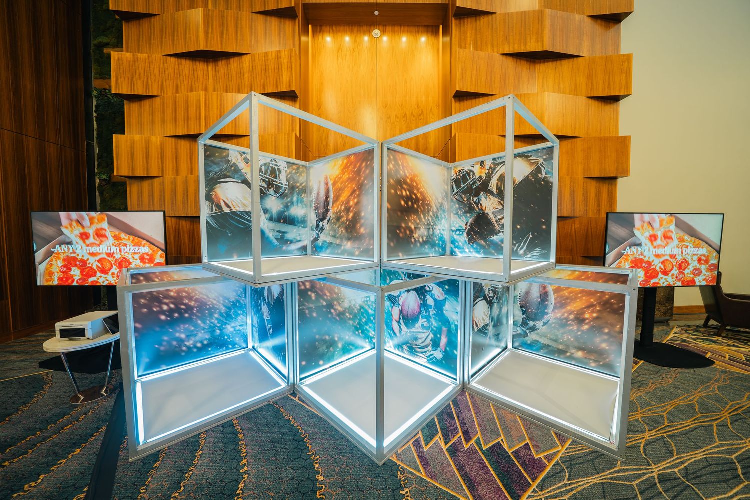 Row of illuminated blue glass display cases in a dimly lit venue.