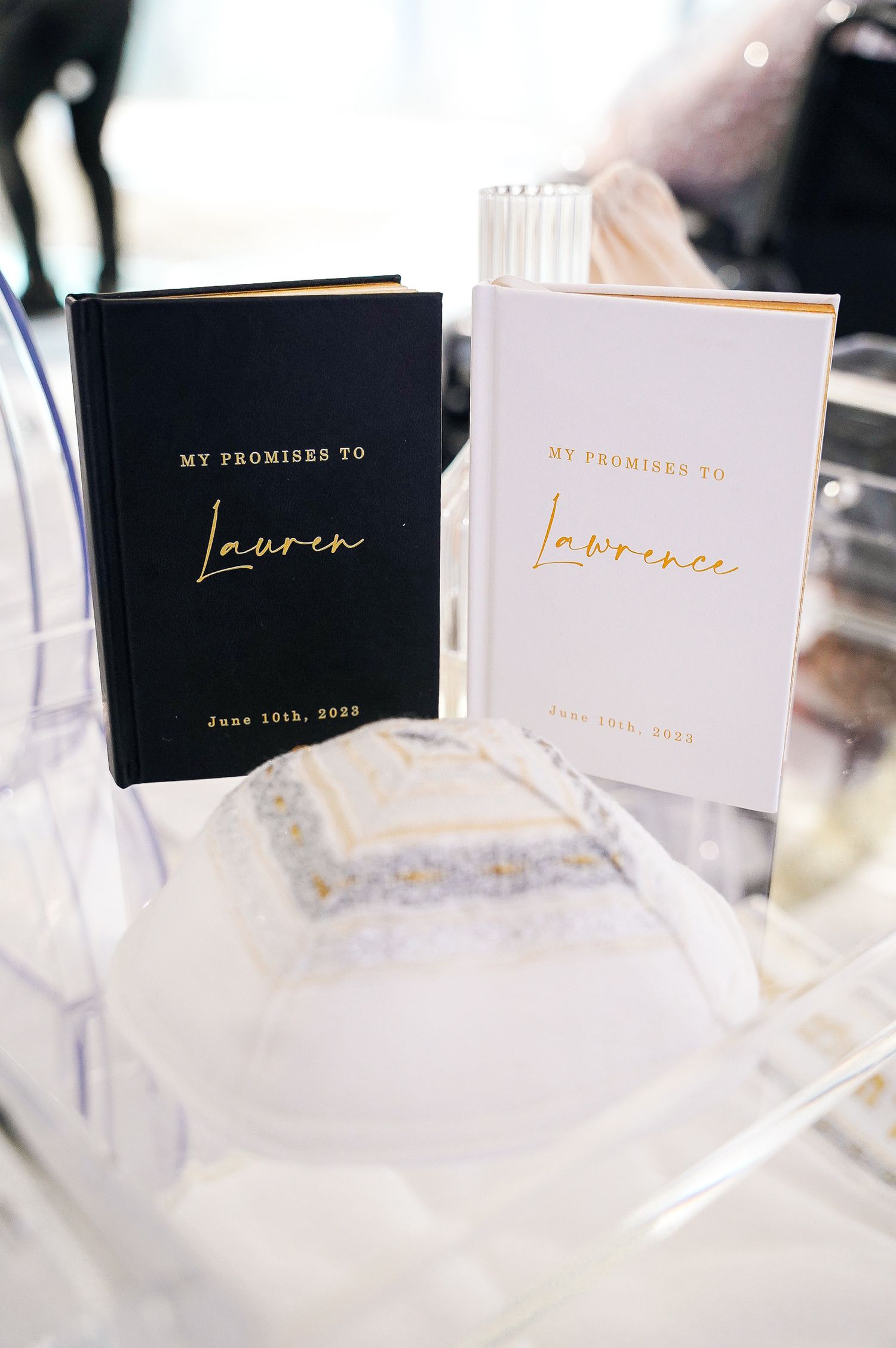 Two elegant wedding vow books in black and white with gold lettering titled 'My Promises To Lauren' displayed together.