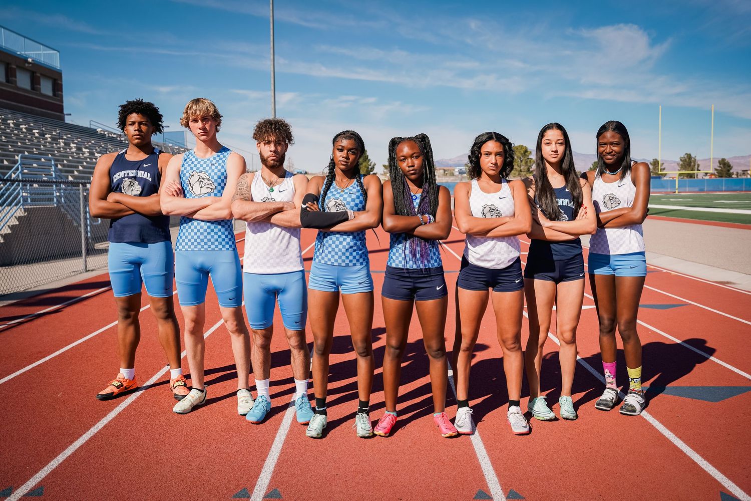 Track team members stand together for group photo on outdoor running track.