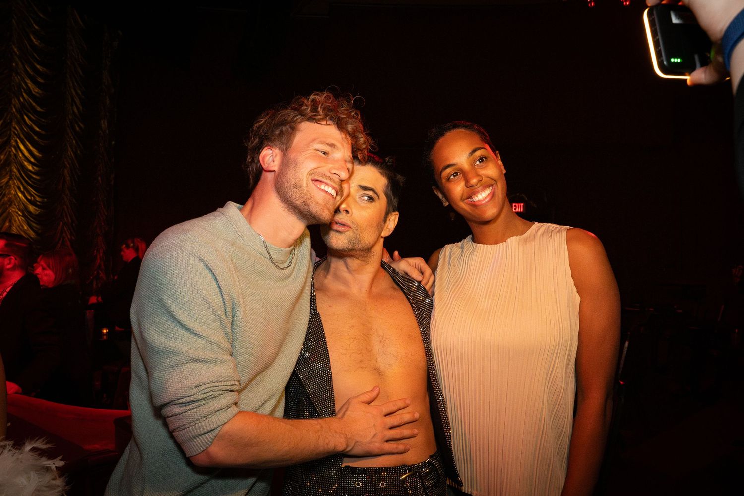Friends sharing a candid moment at nighttime entertainment venue.