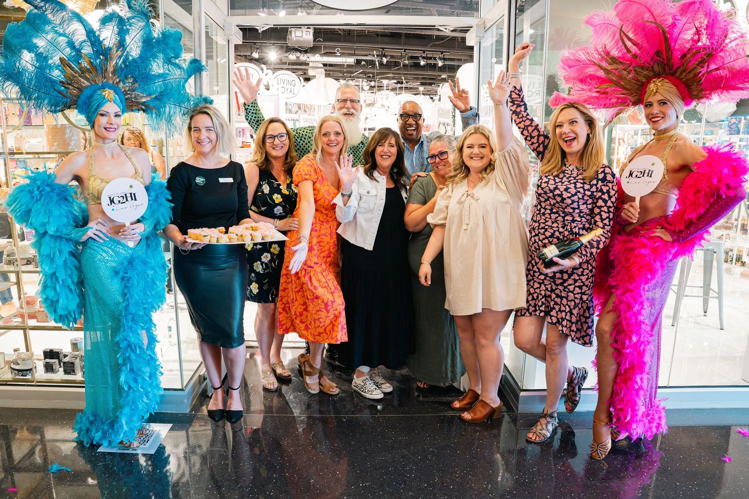 Group photo with colorful feather boas at retail store grand opening celebration.