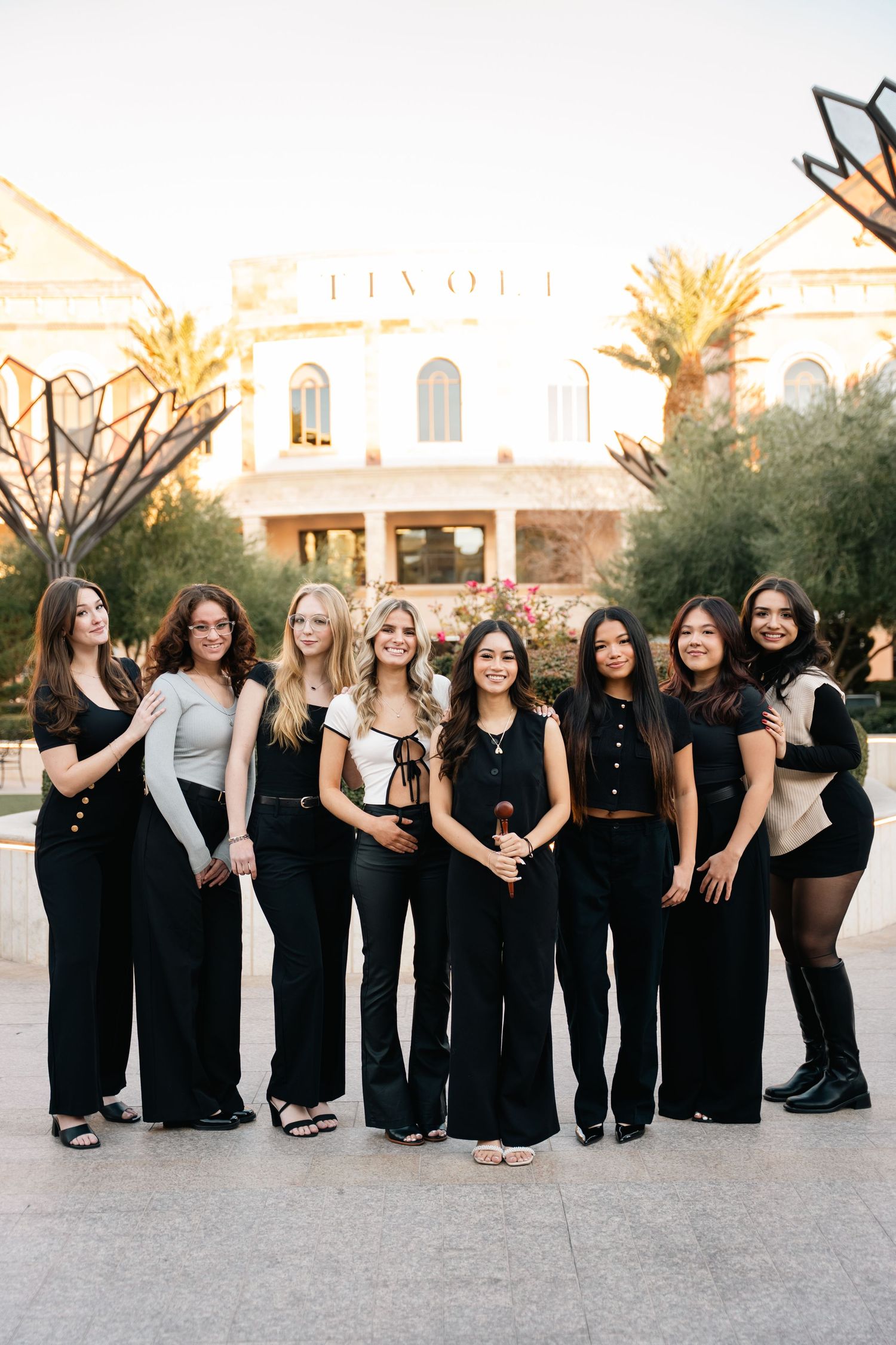 Group photo of friends in coordinated black attire posing outside the Tivoli building.