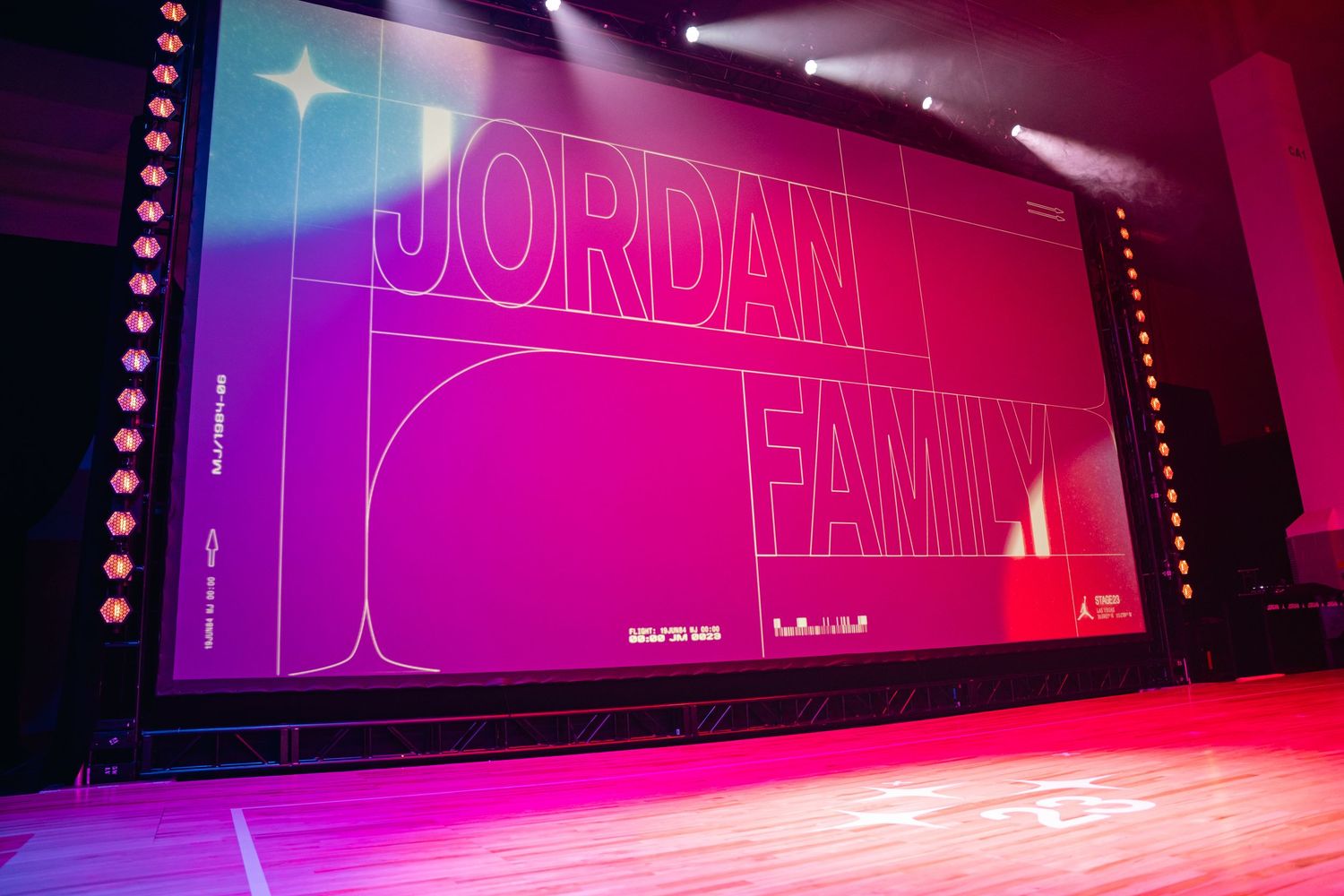 Illuminated stage with vibrant pink and blue lighting creating a dramatic atmosphere with neon signage.