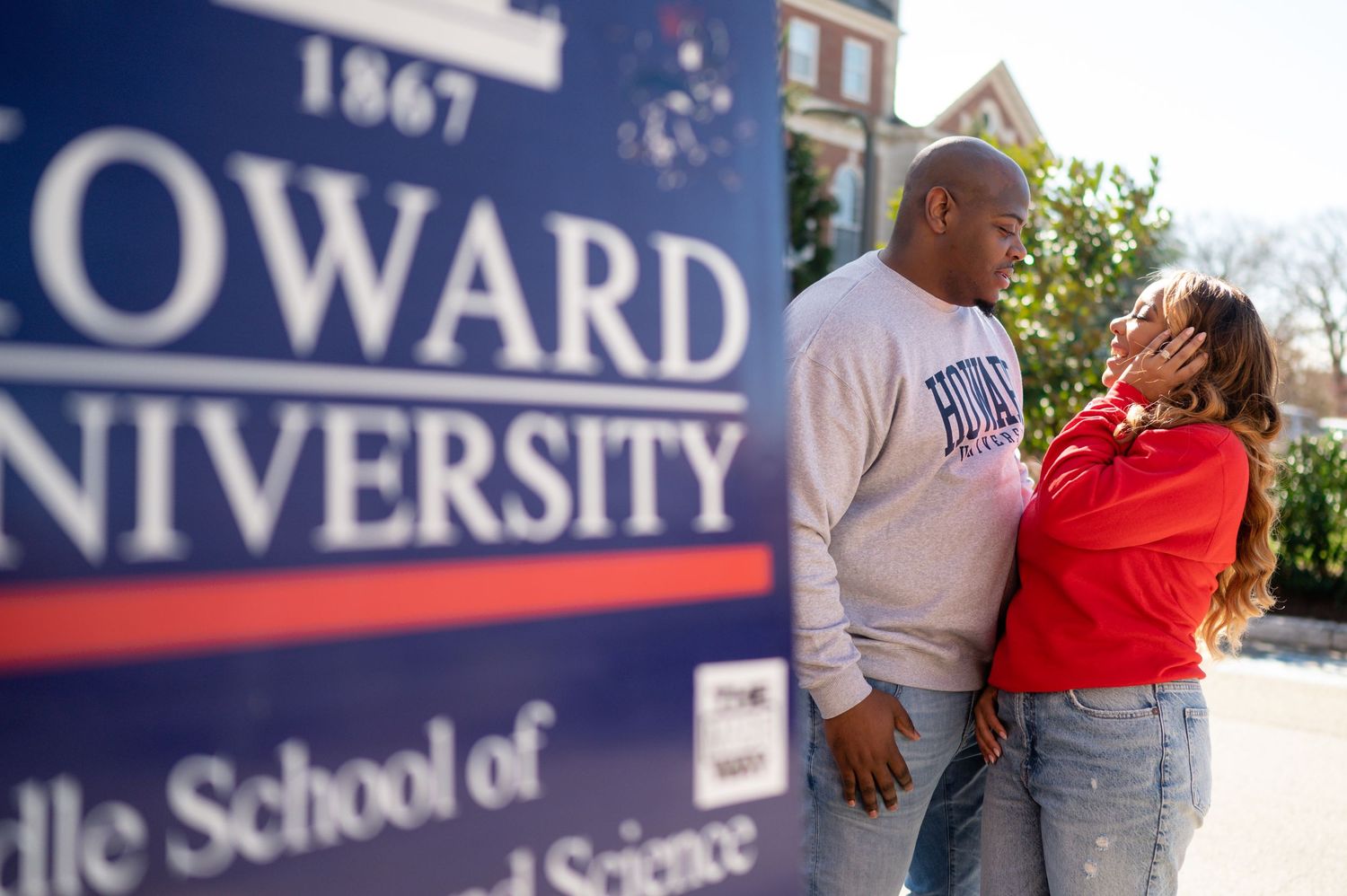Students walk past Howard University signage and buildings on a sunny day at the historic campus in Washington DC.