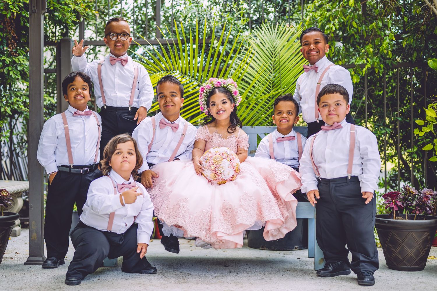 Group photo on garden patio with formal attire and pink dress.