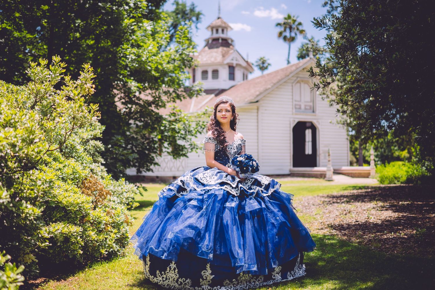 A collection of photos featuring someone in a flowing royal blue quinceañera dress posing in outdoor garden settings.
