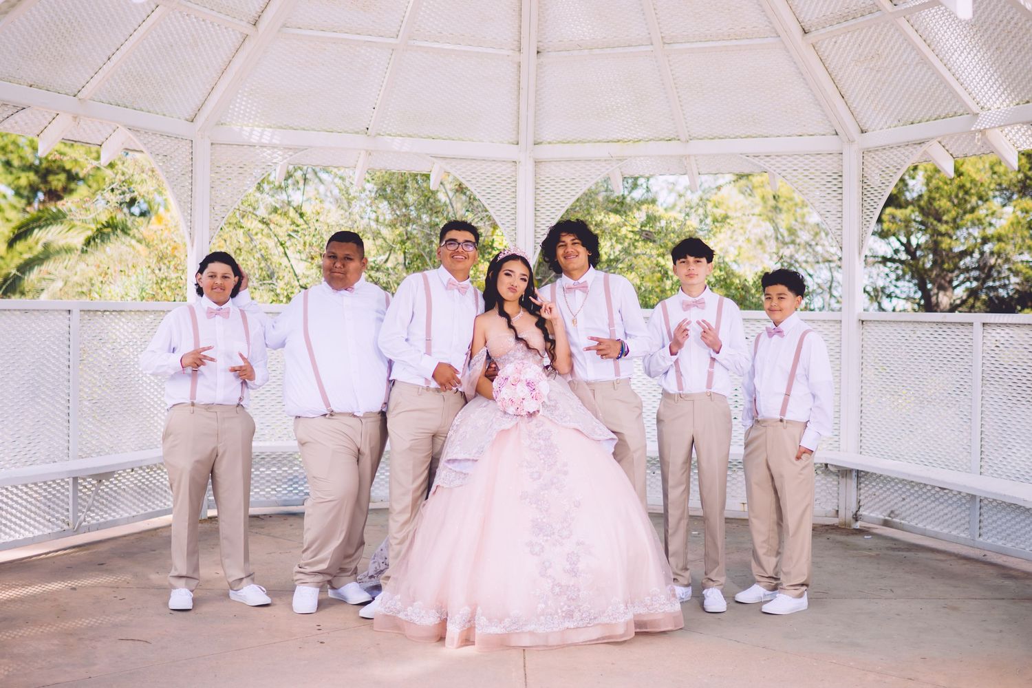A coordinated group photo with party members wearing white and khaki outfits in a white gazebo.