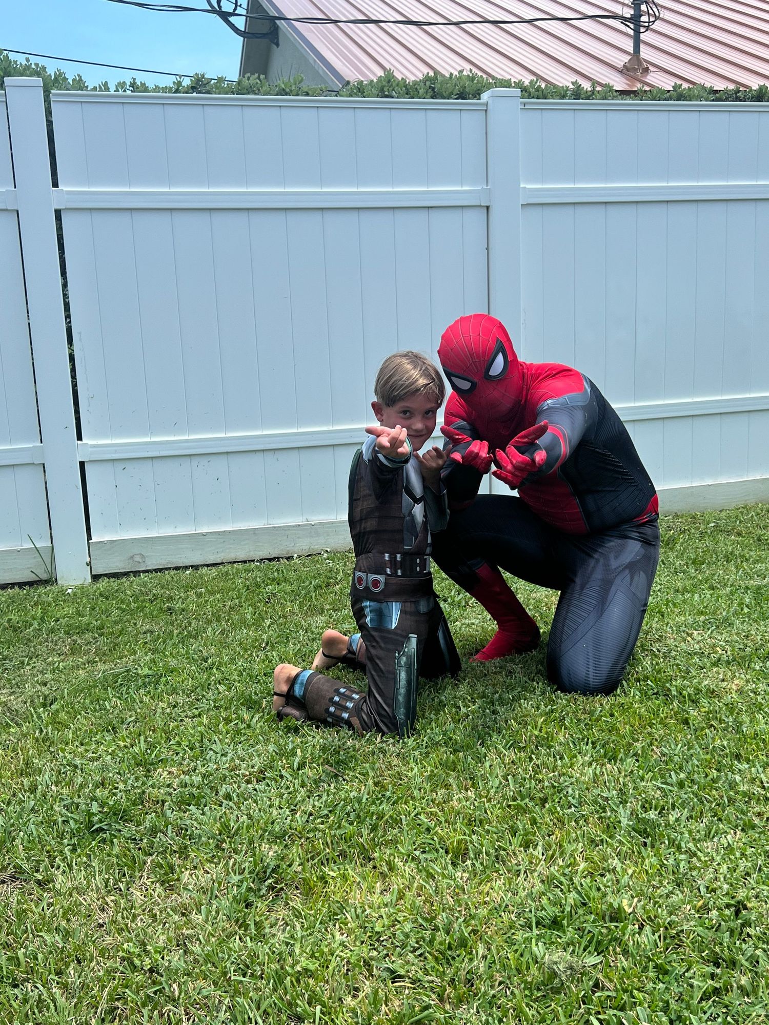 spiderman poses with small child
