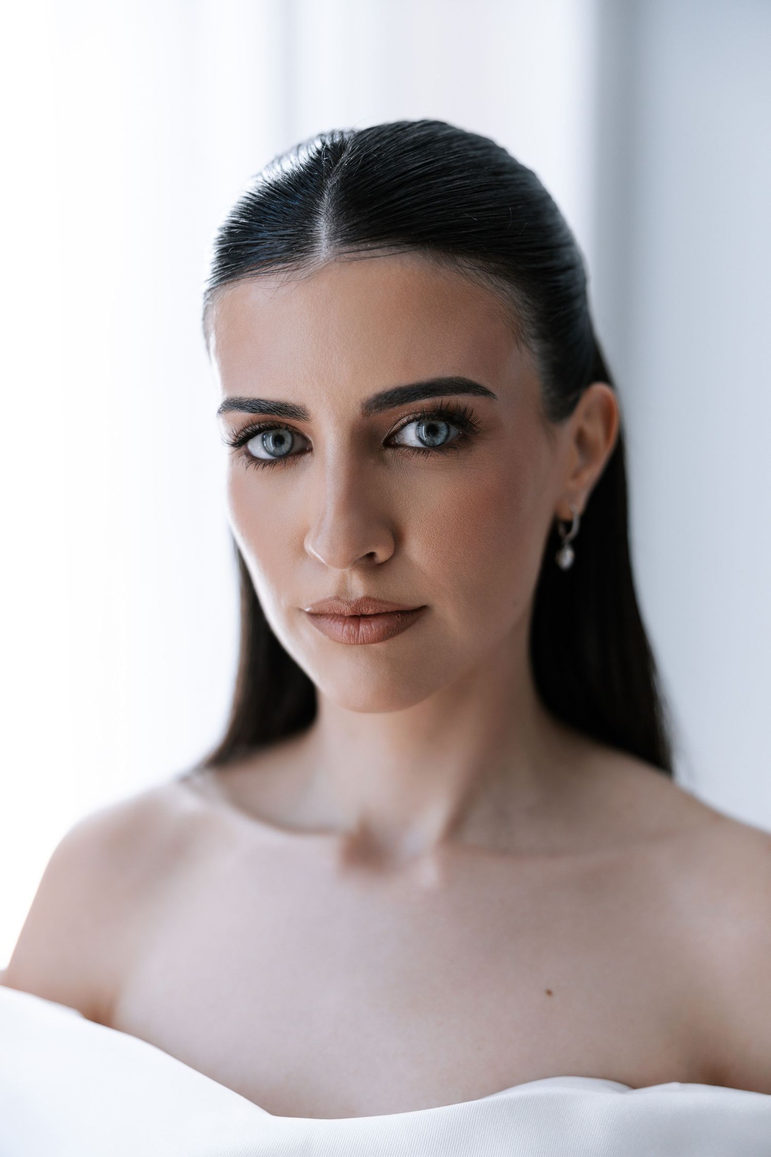 Artistic portrait series showing close-up facial features with soft lighting and minimalist white background.