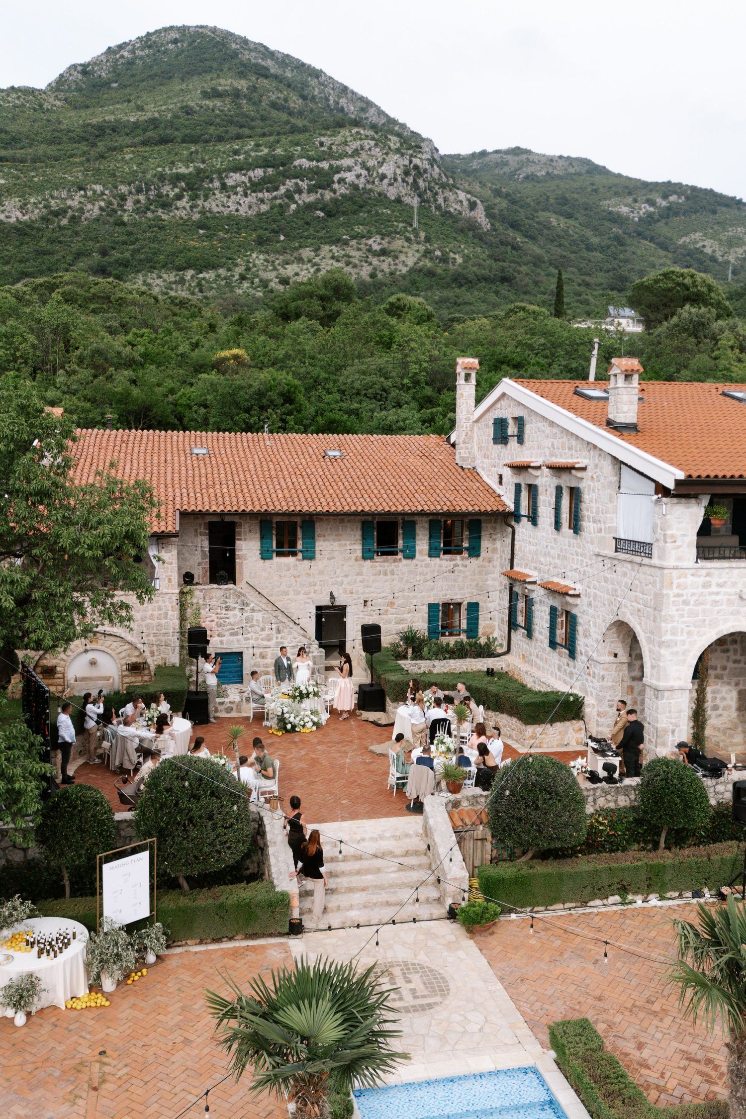 Stone villa with red-tiled roofs and swimming pool nestled in the mountains of Montenegro showcases traditional architecture.