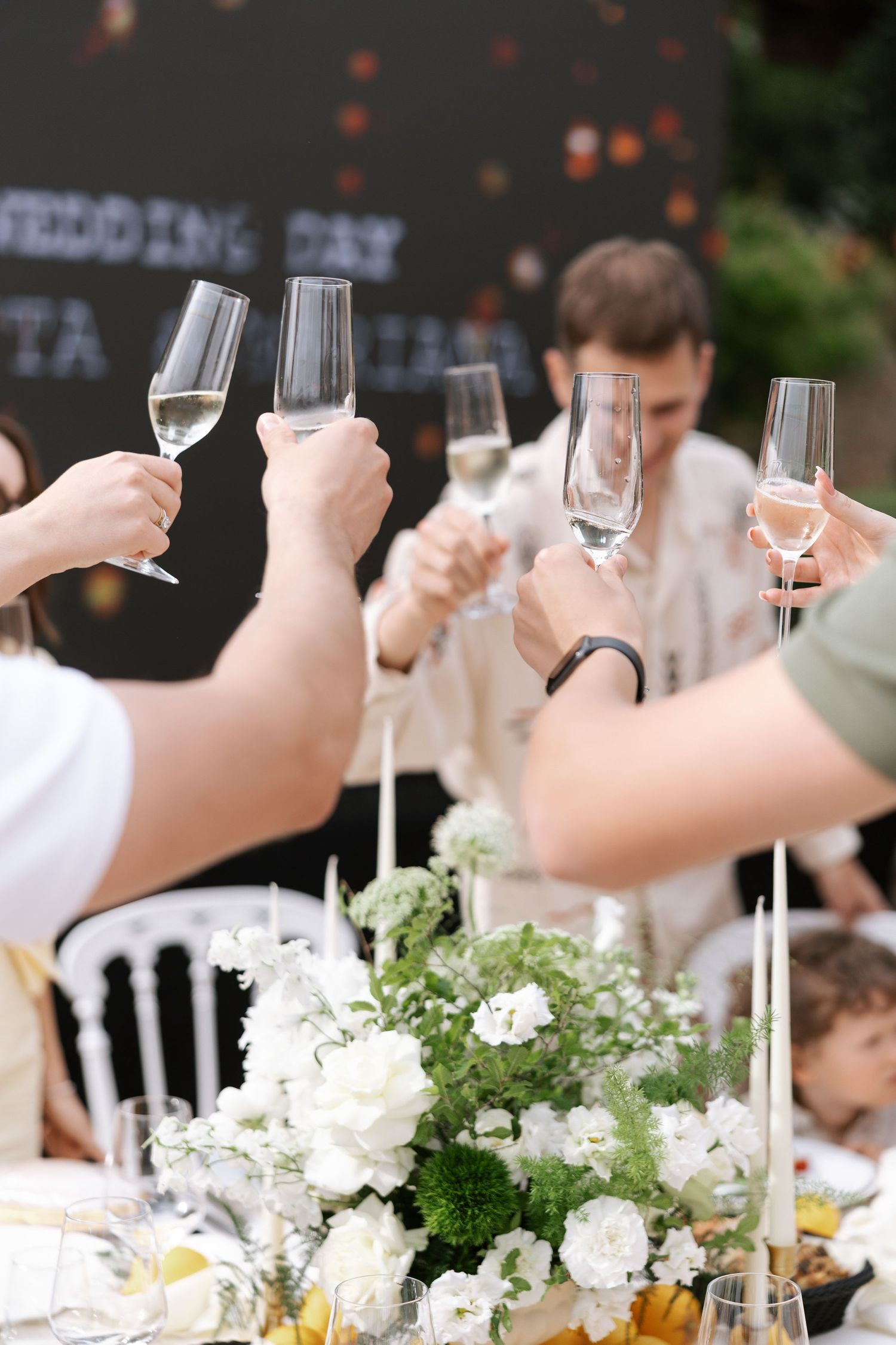 Champagne glasses and white floral centerpieces line an elegant dinner table at a formal event.