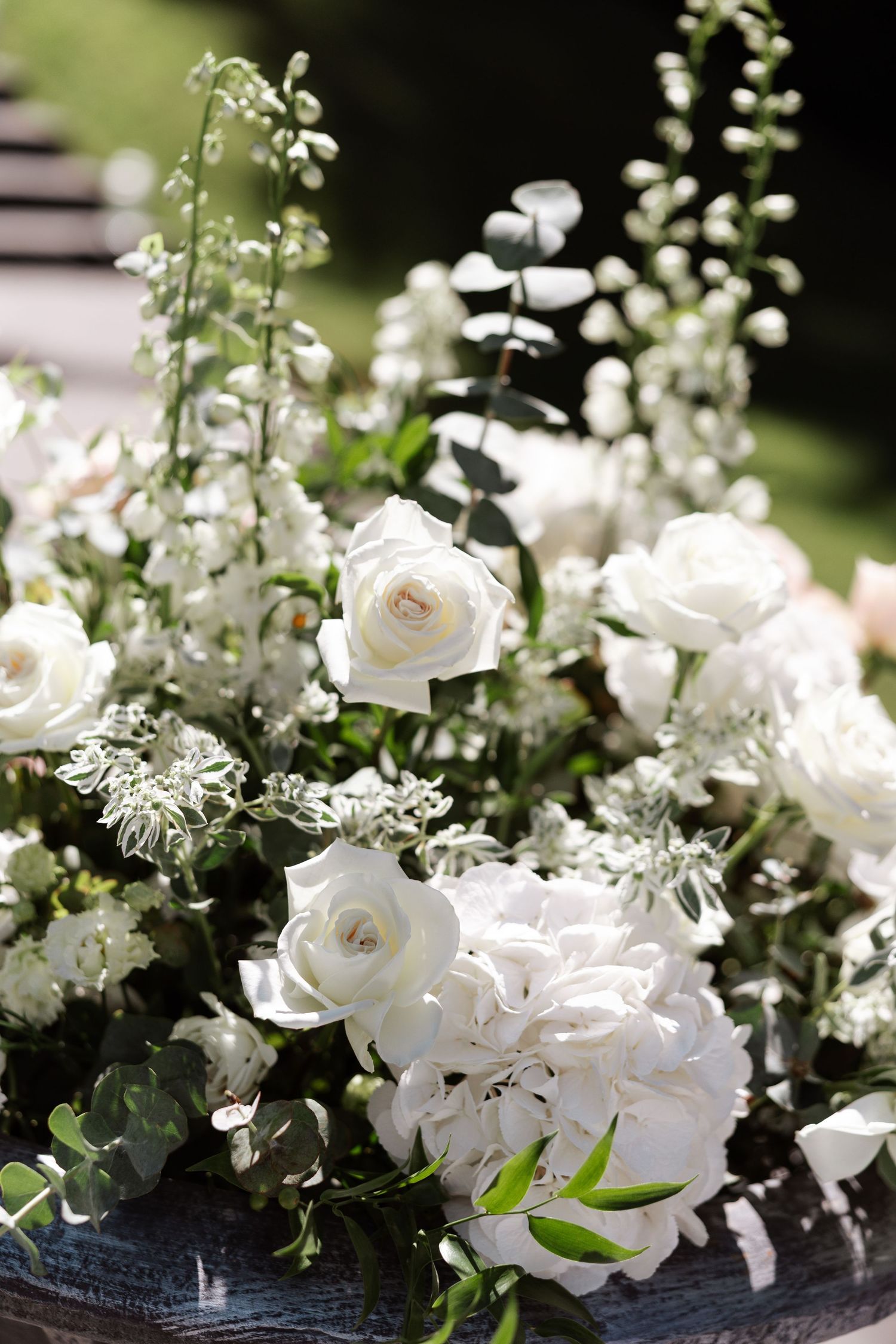 Elegant white floral arrangements featuring roses and delicate blooms against a dark background.