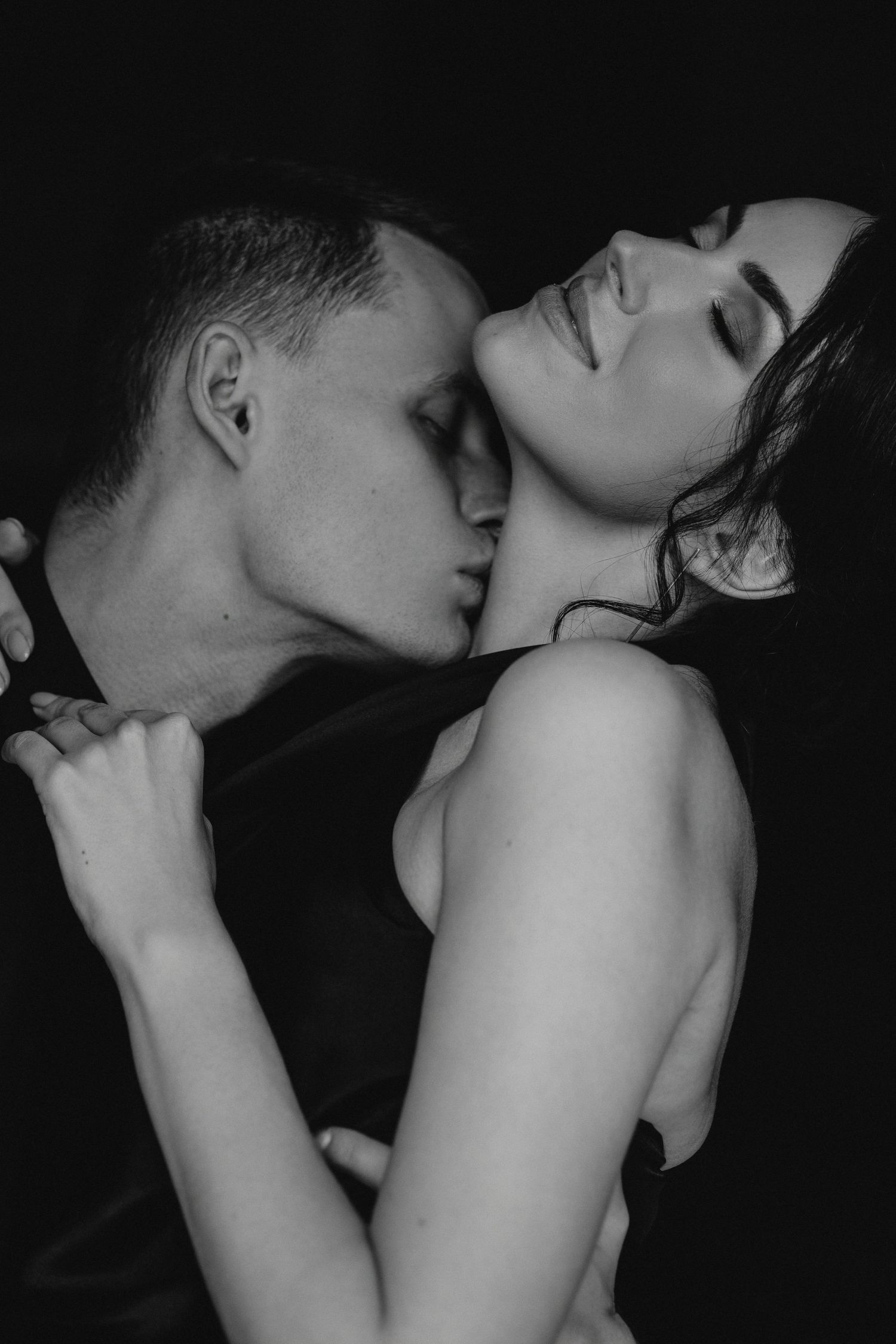 Intimate black and white portrait capturing tender moment between couple.