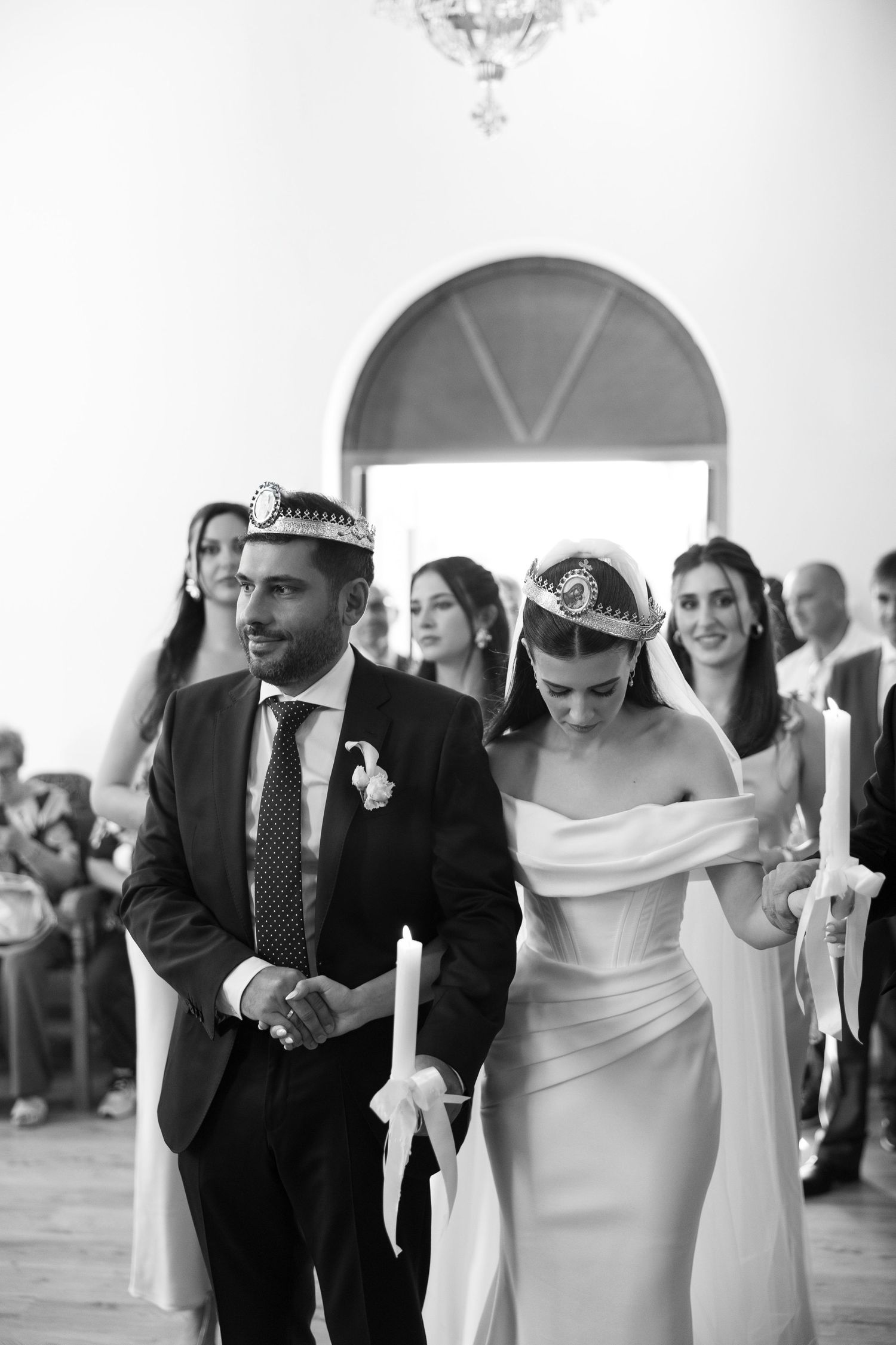 A wedding couple walks down a church aisle in a series of black and white photographs showing their joyful procession.