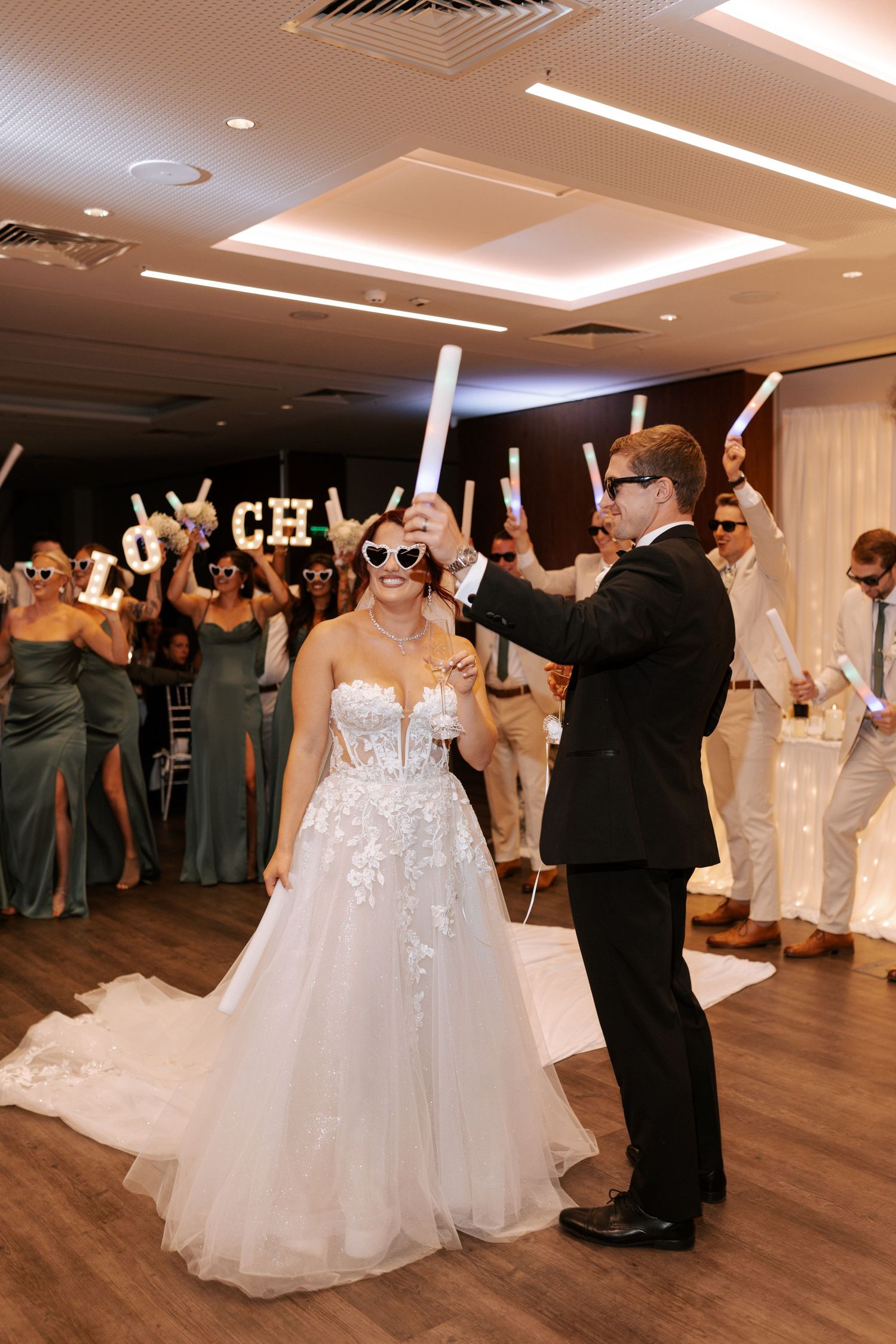 Celebration at wedding reception with LED foam sticks and dance floor entertainment.