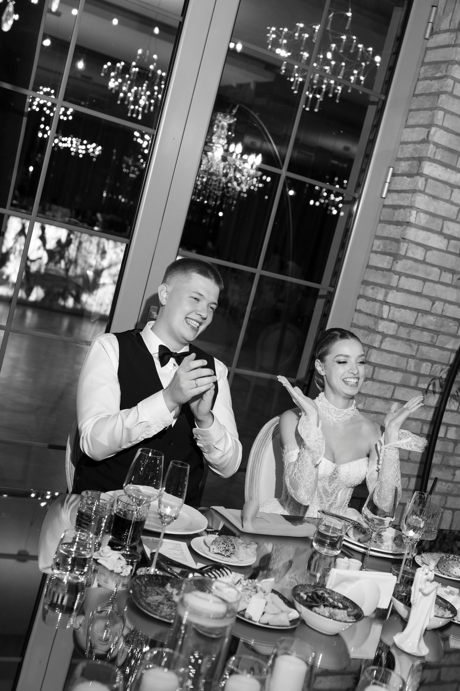 Wedding reception dinner scene with guests enjoying a meal under twinkling lights.